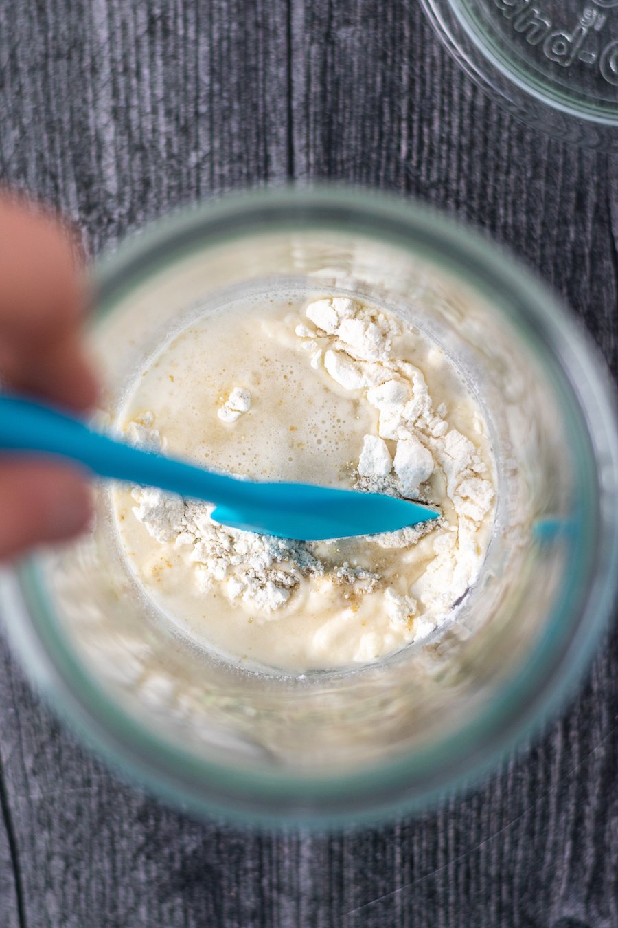 Stirring flour and water in jar for sourdough starter