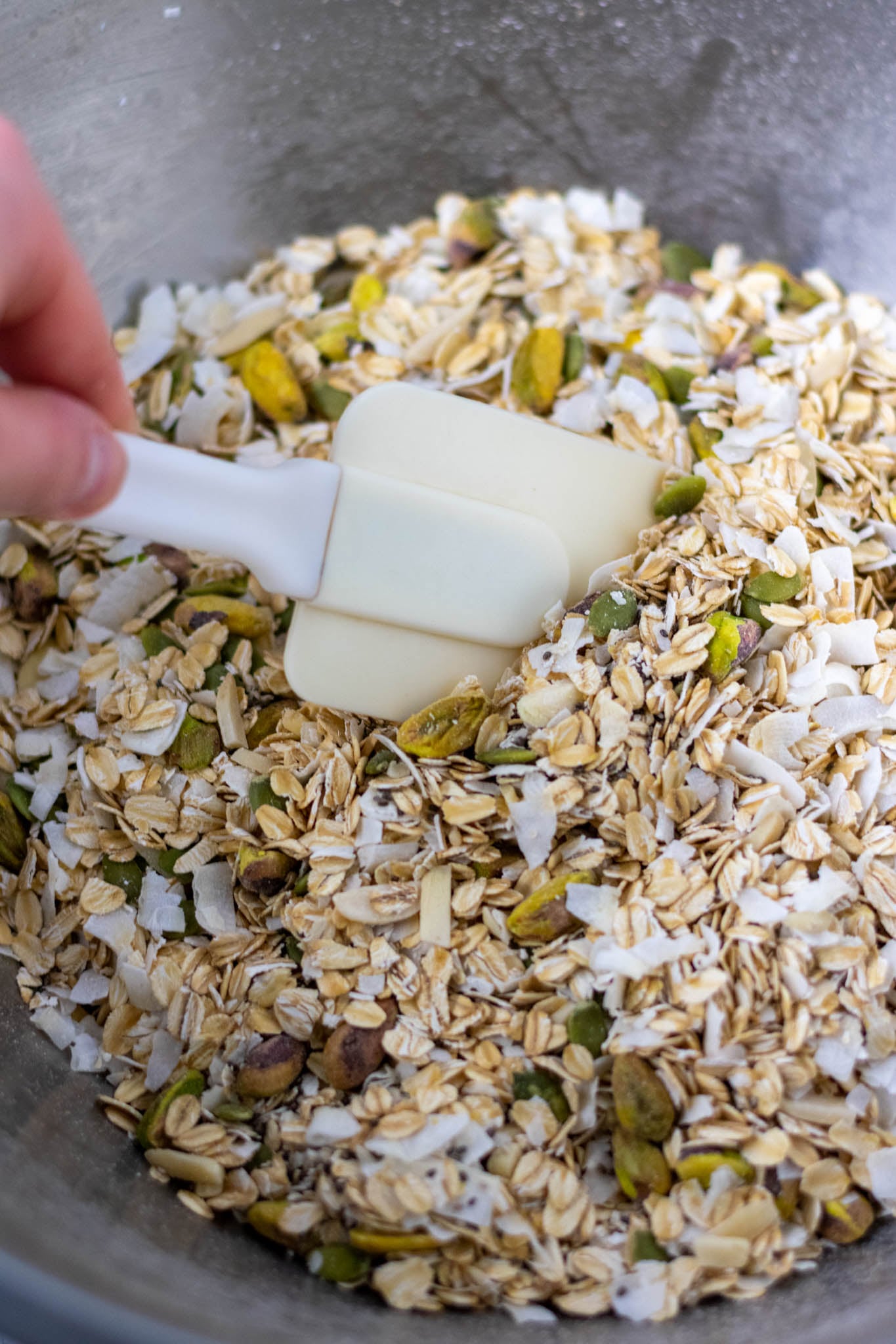 Stirring dry ingredients with spatula in mixing bowl