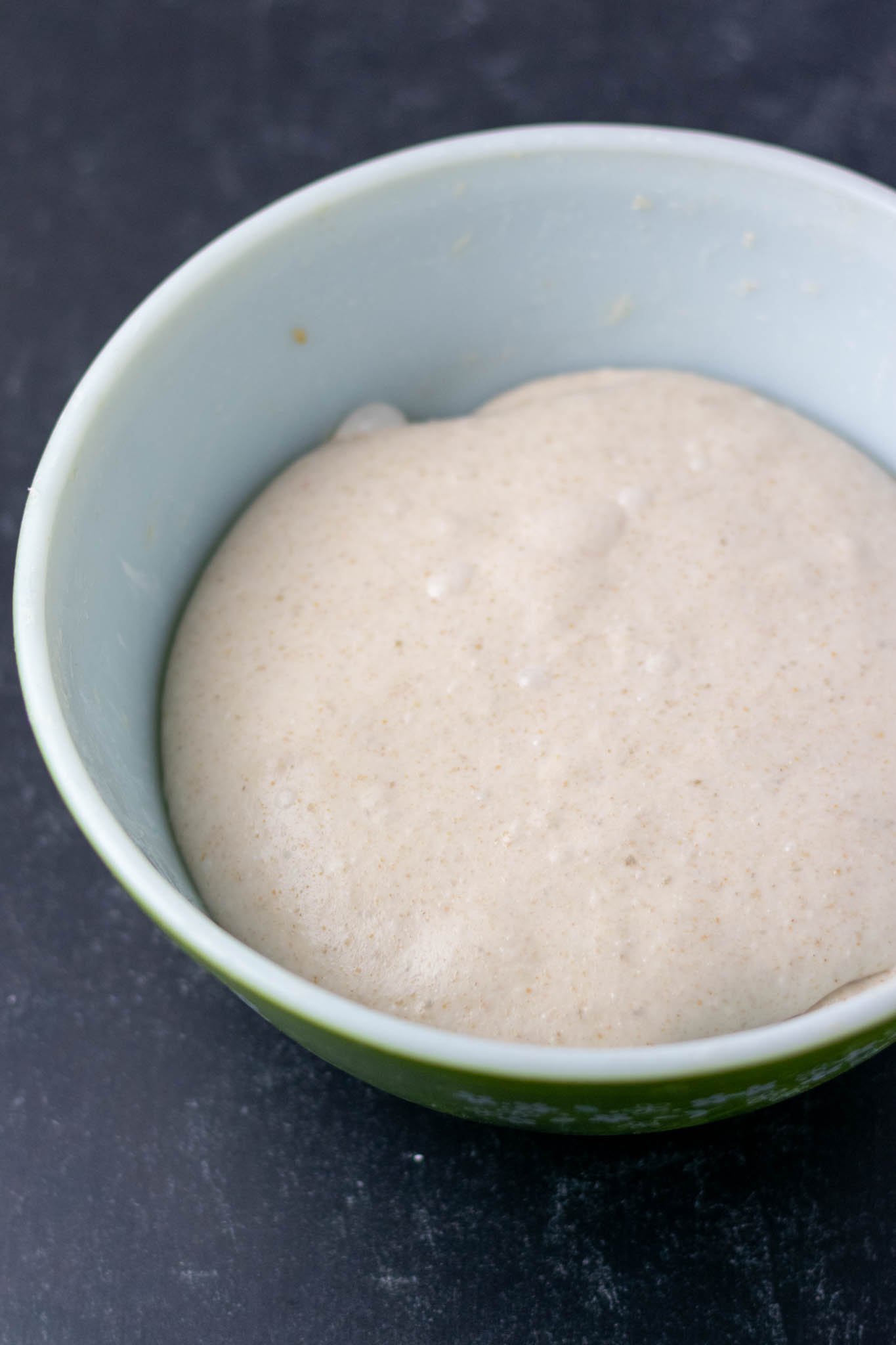 Slight overhead shot of dough with bubbles and smooth after bulk fermentation