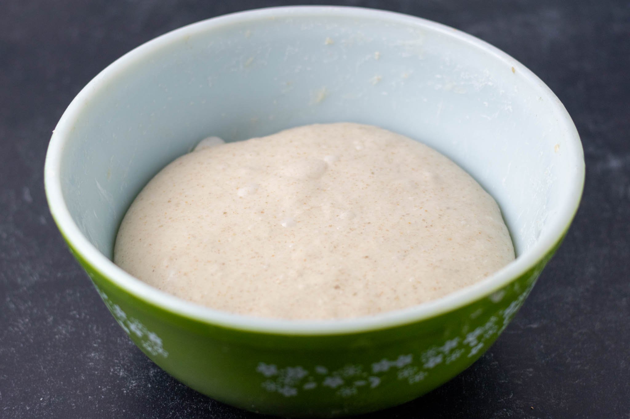 Smooth and bubbly dough after bulk fermentation in mixing bowl