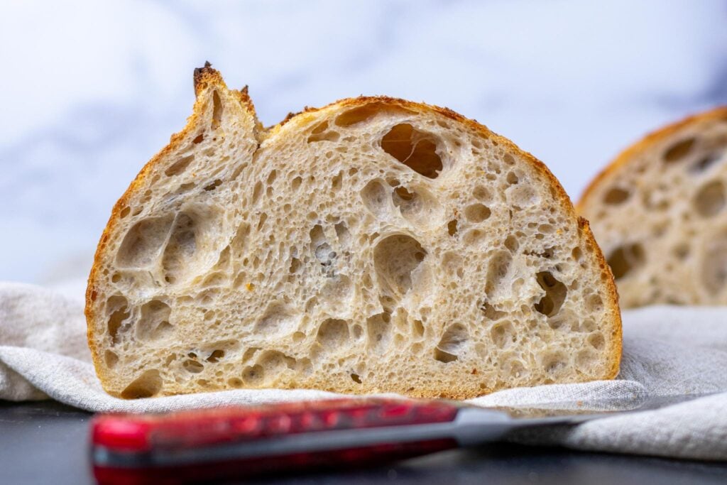 My everyday sourdough bread crumbshot sliced with open crumb and bread knife