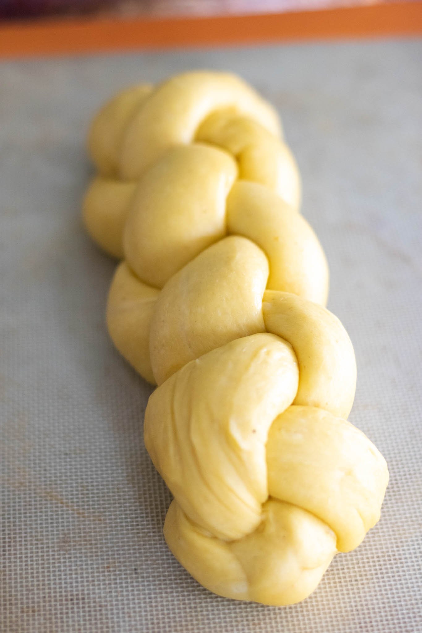 Braided sourdough challah on sheet pan