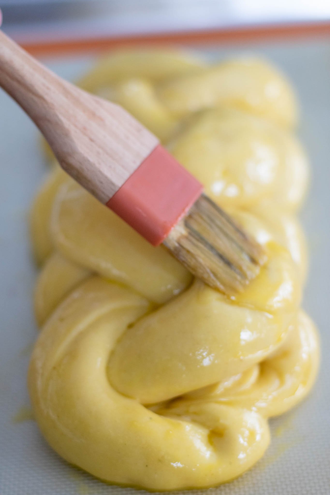 Brushing egg on sourdough challah