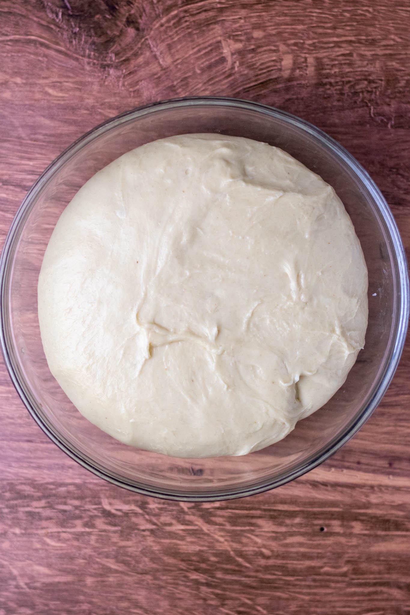 Overhead of bigger dough in glass bowl at end of bulk fermentation