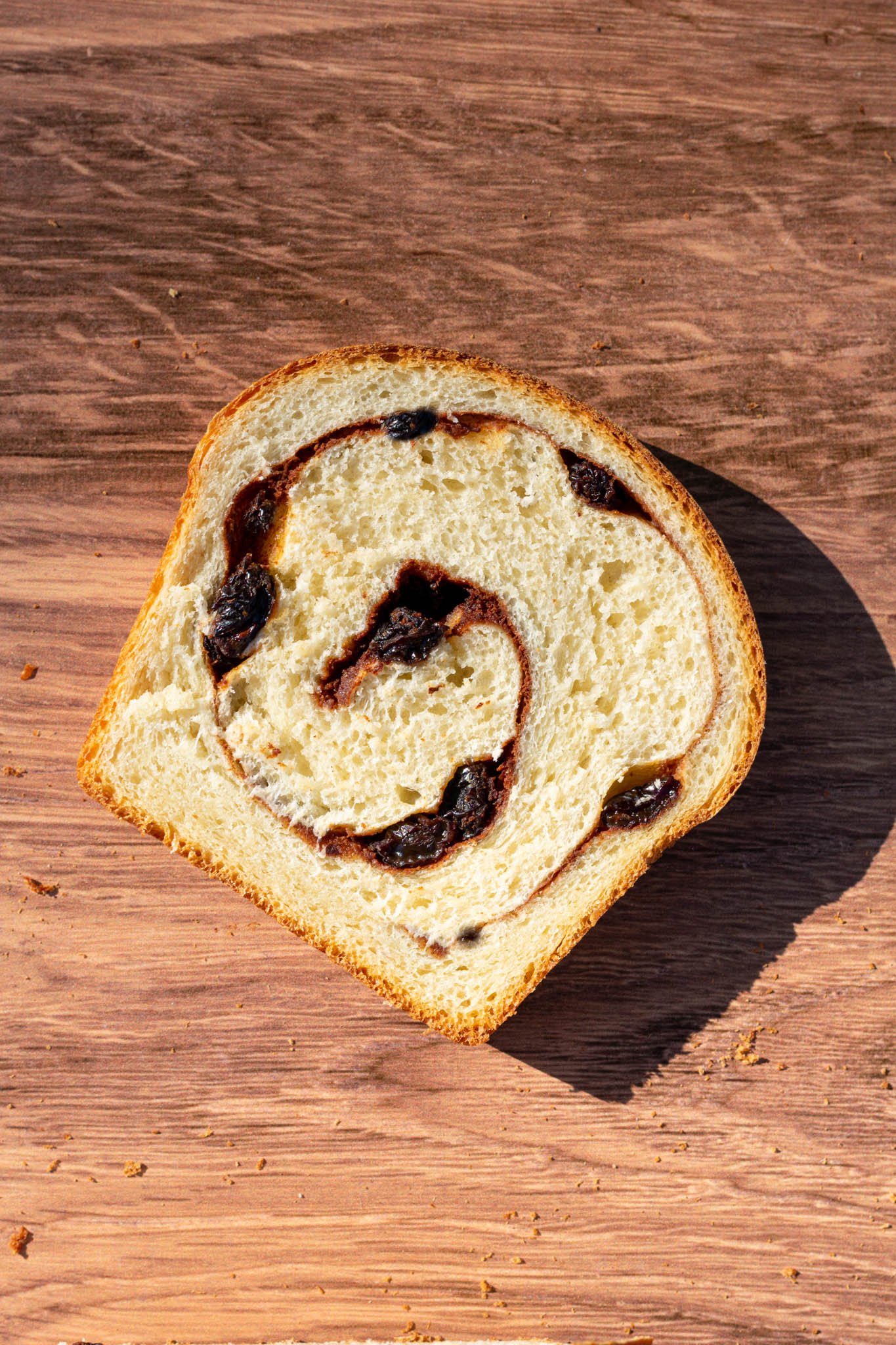 Single slice of sourdough cinnamon raisin swirl bread on table