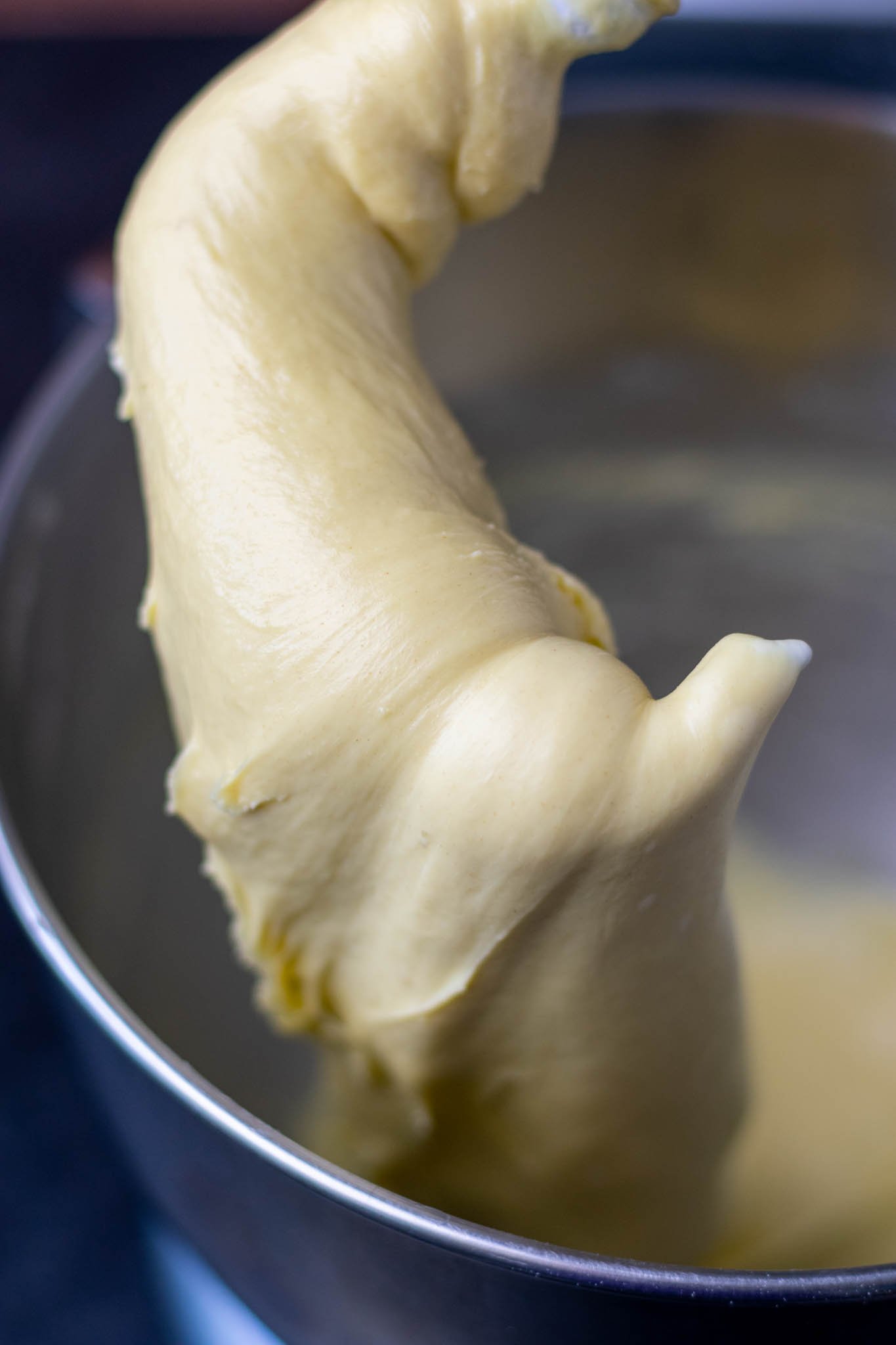 Silky brioche dough on dough hook at end of mixing