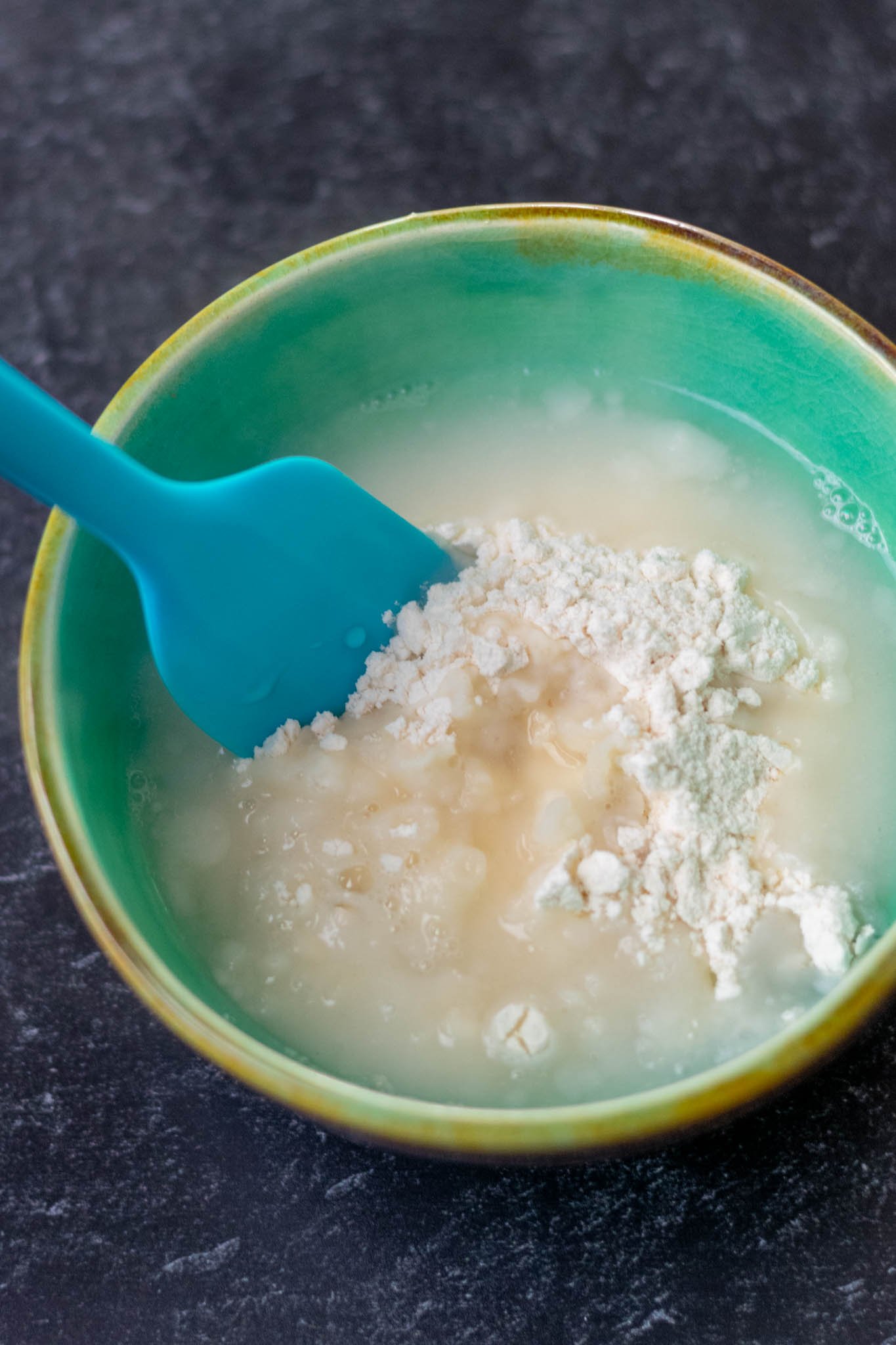 Mixing yudane flour and boiling water in bowl with spatula