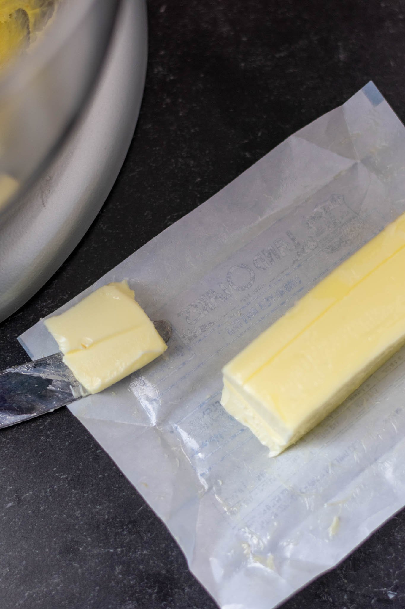 Stick of softened butter unwrapped with butter knife