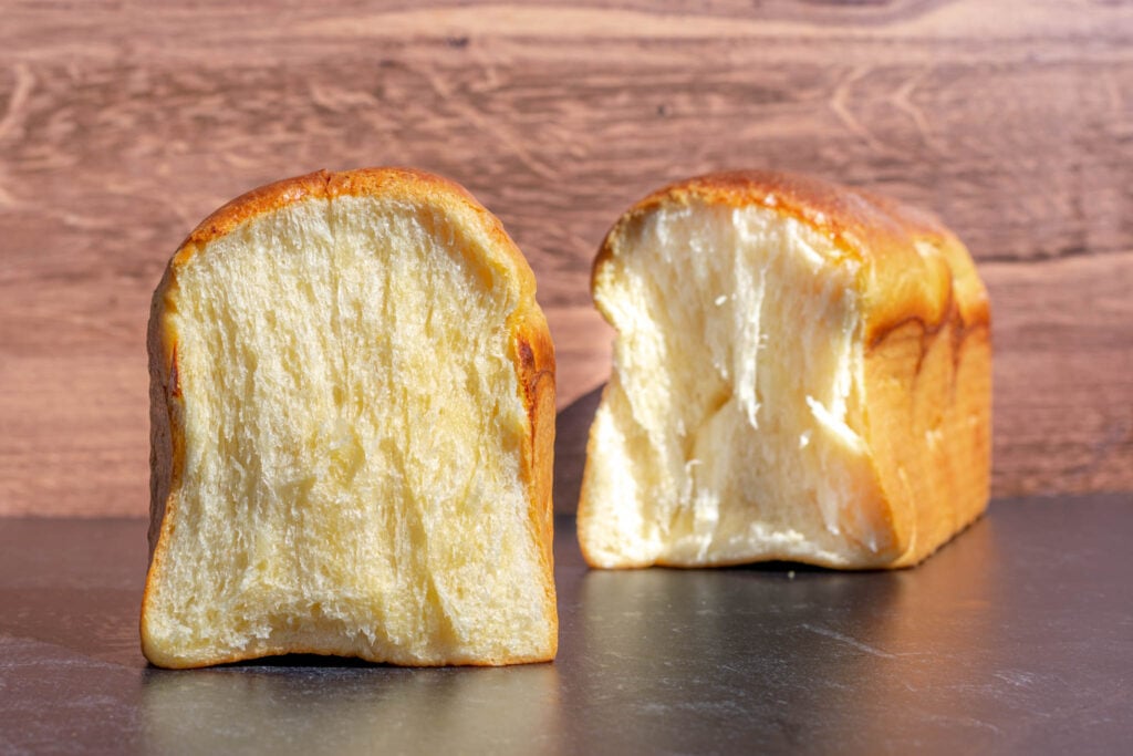 Crumbshot of sourdough brioche with loaf in background