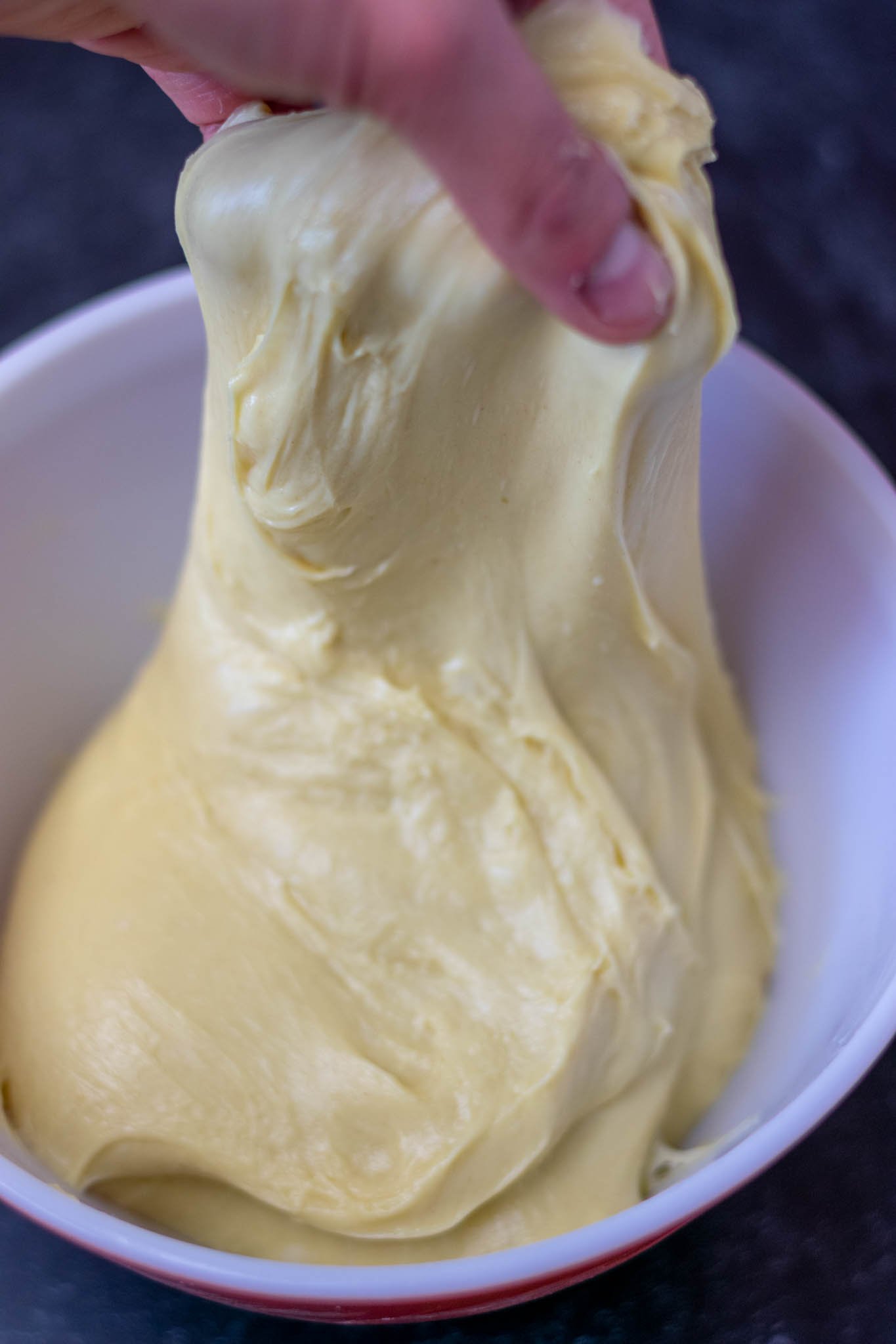 Stretch and fold of sourdough brioche dough in mixing bowl