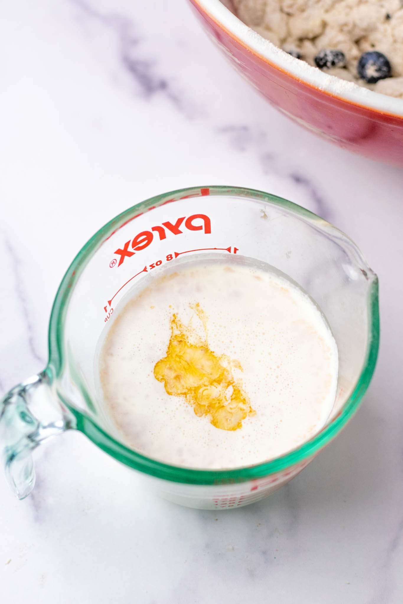 Measuring cup of heavy cream and vanilla