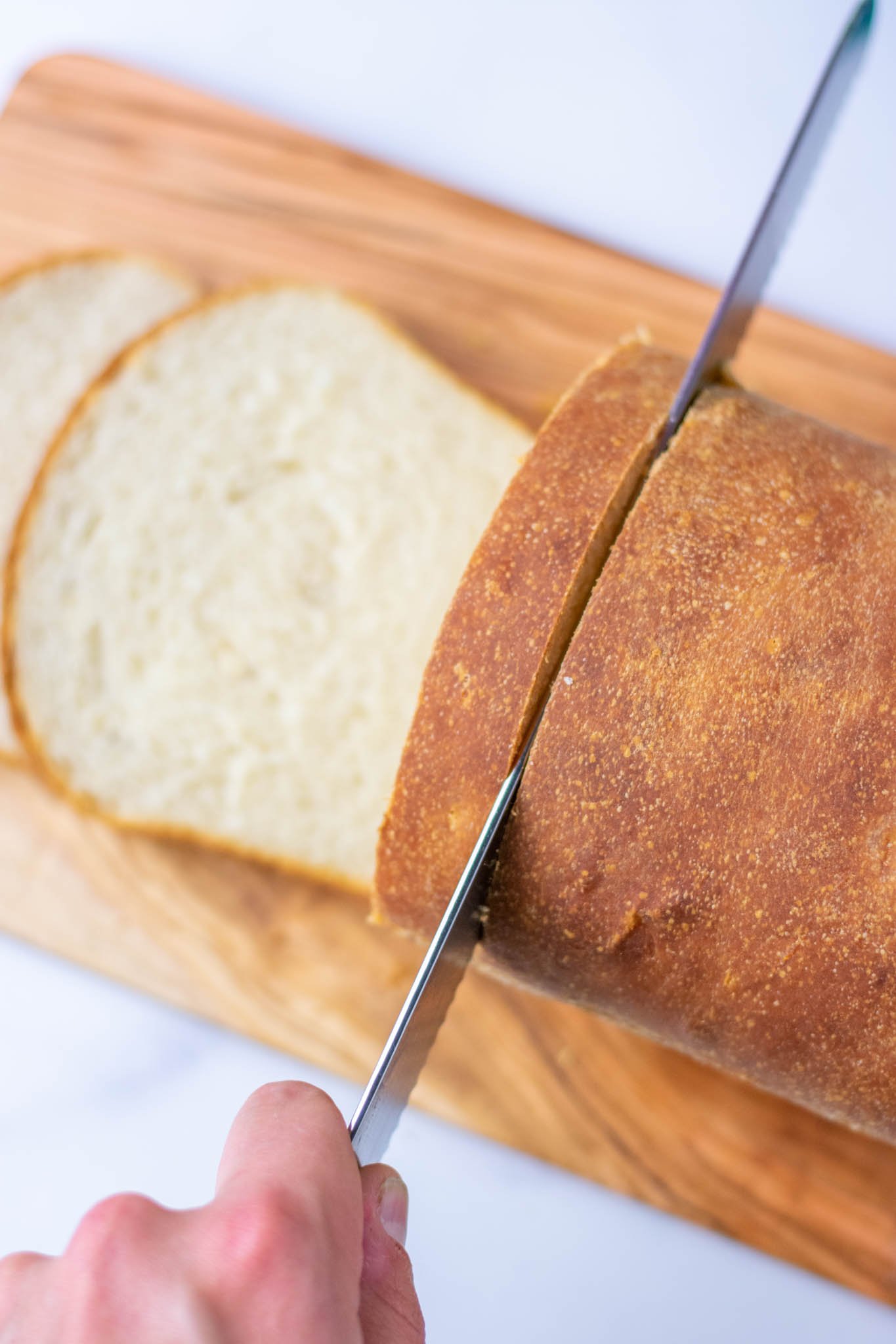 Slicing sourdough sandwich bread with bread knife