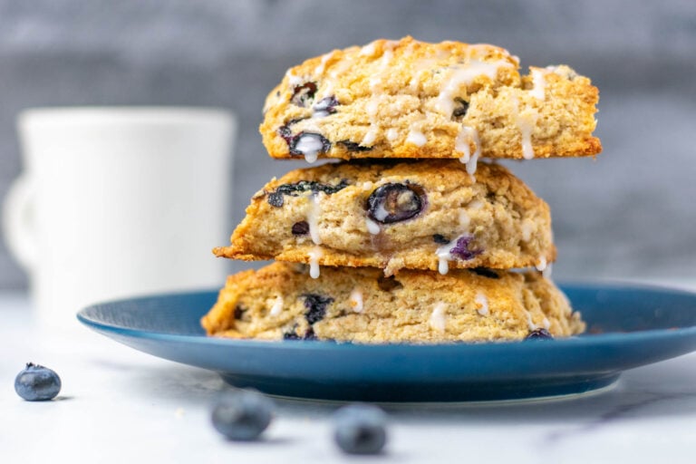 Sourdough discard blueberry scones on plate with dripping icing