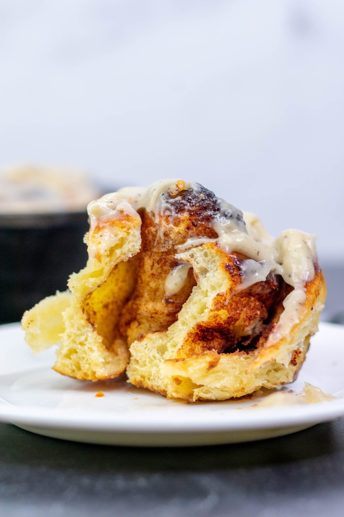 Bite taken from a Sourdough cinnamon roll on a plate