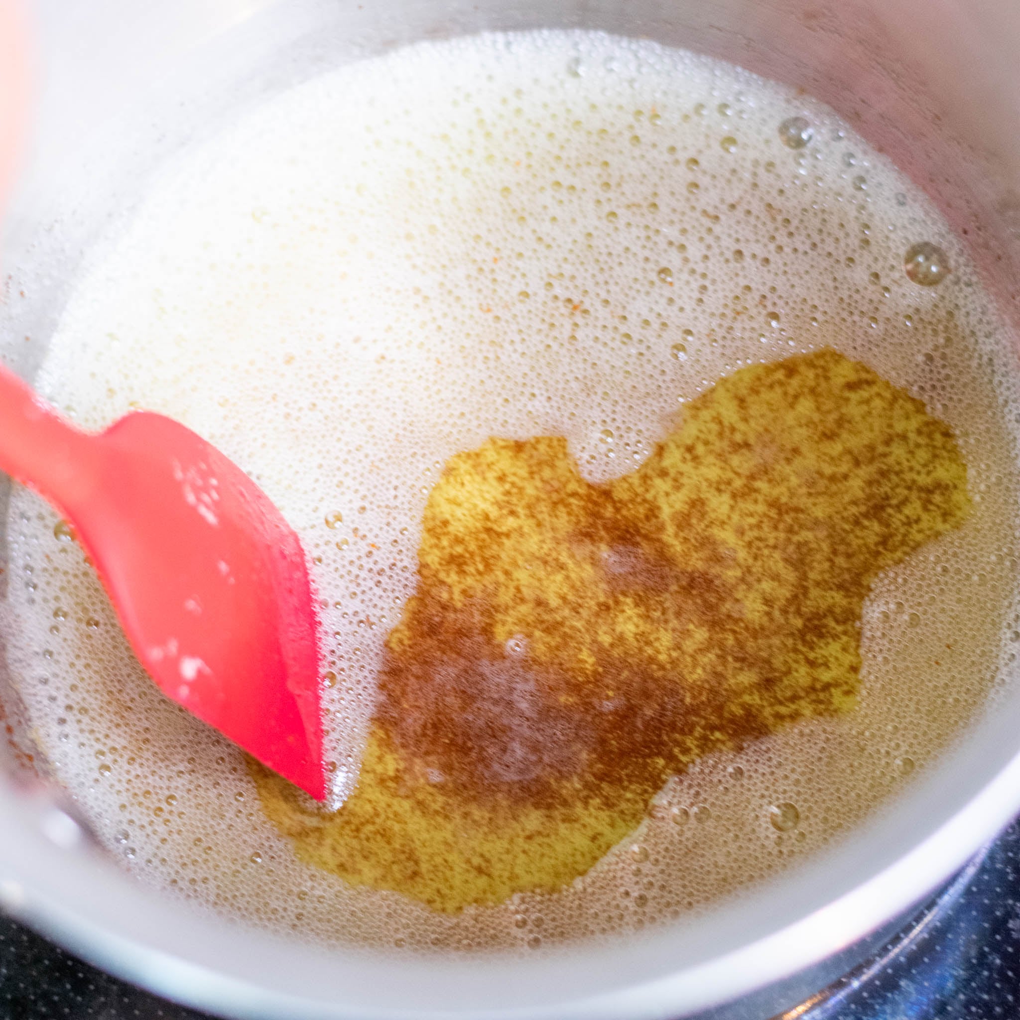 Spatula stirring brown butter in saucepan