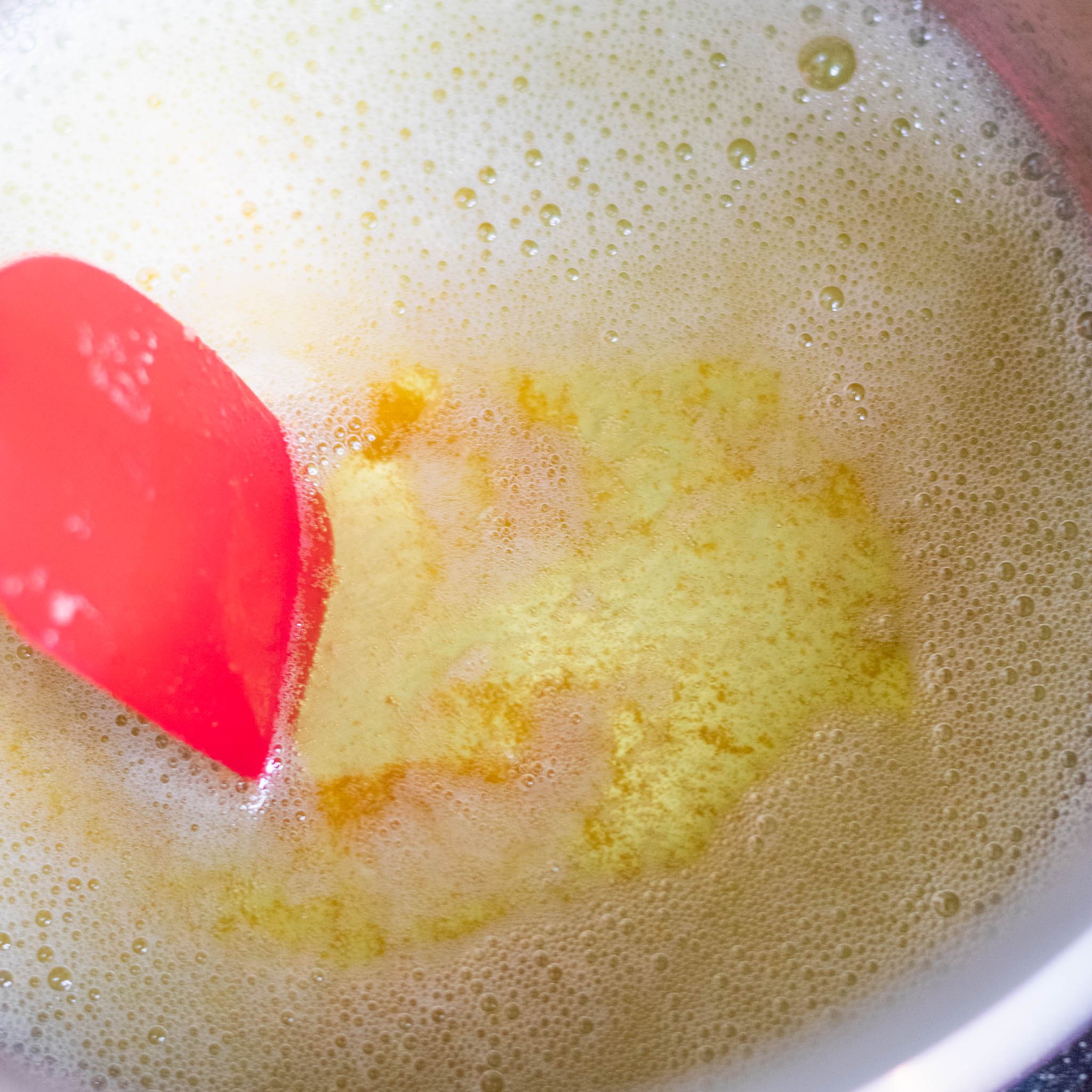 Bubbly butter in sauce pan with some brown specks on the bottom