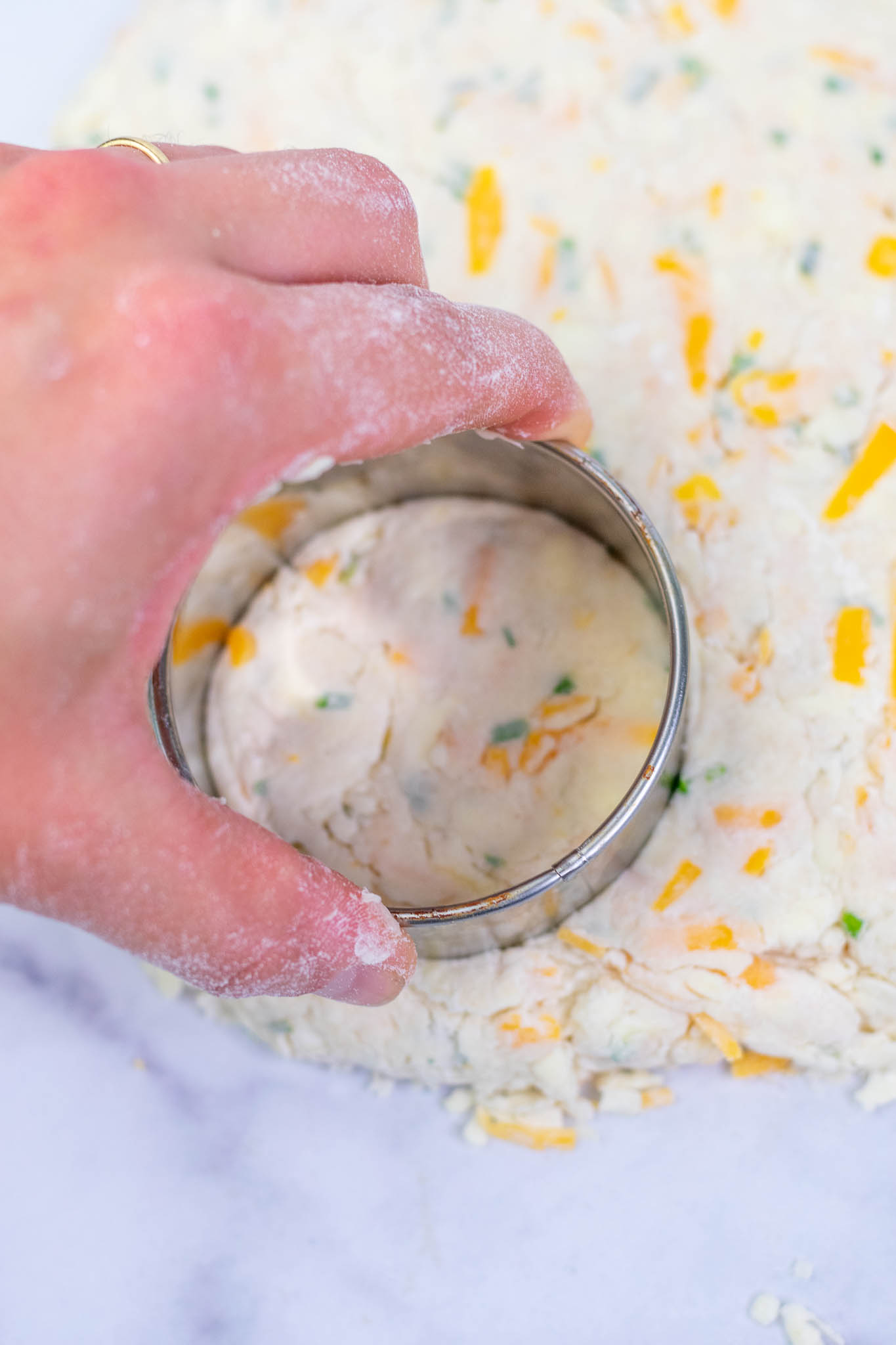 Cutting out a sourdough biscuit with a round biscuit cutter