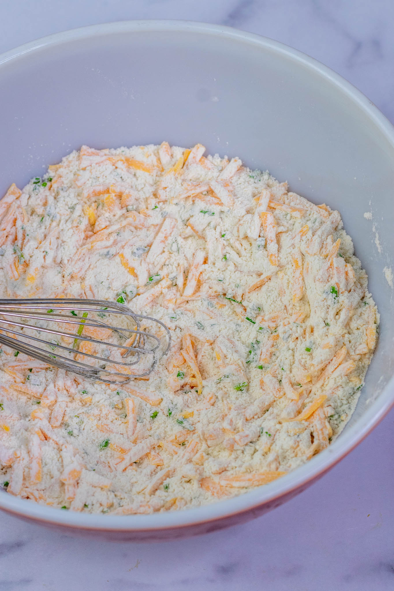 Whisking dry ingredients for biscuit dough together in mixing bowl