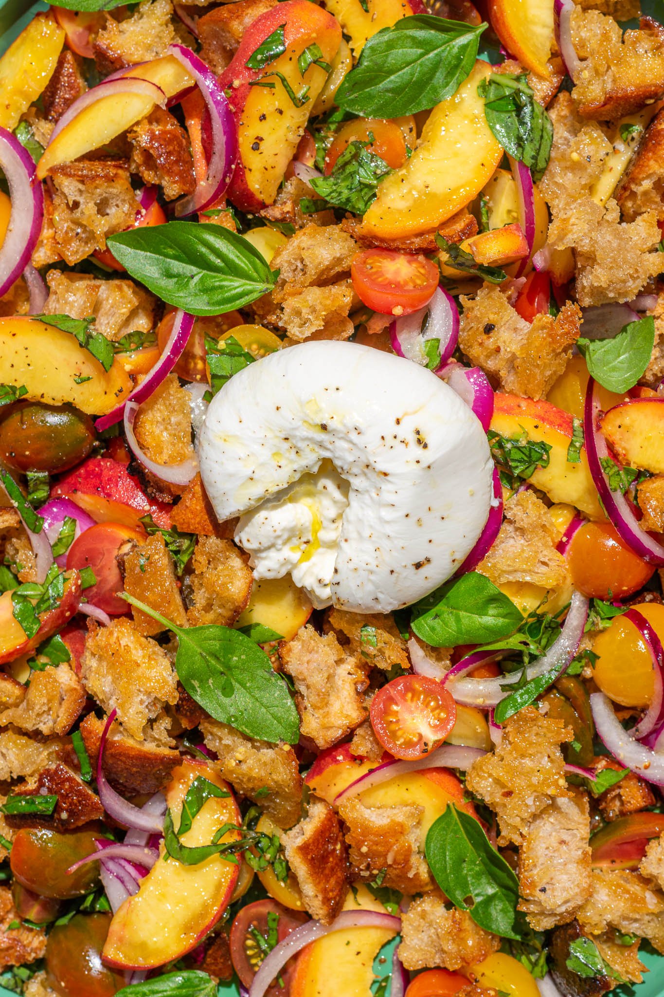 Burrata on top of sourdough panzanella salad with peaches