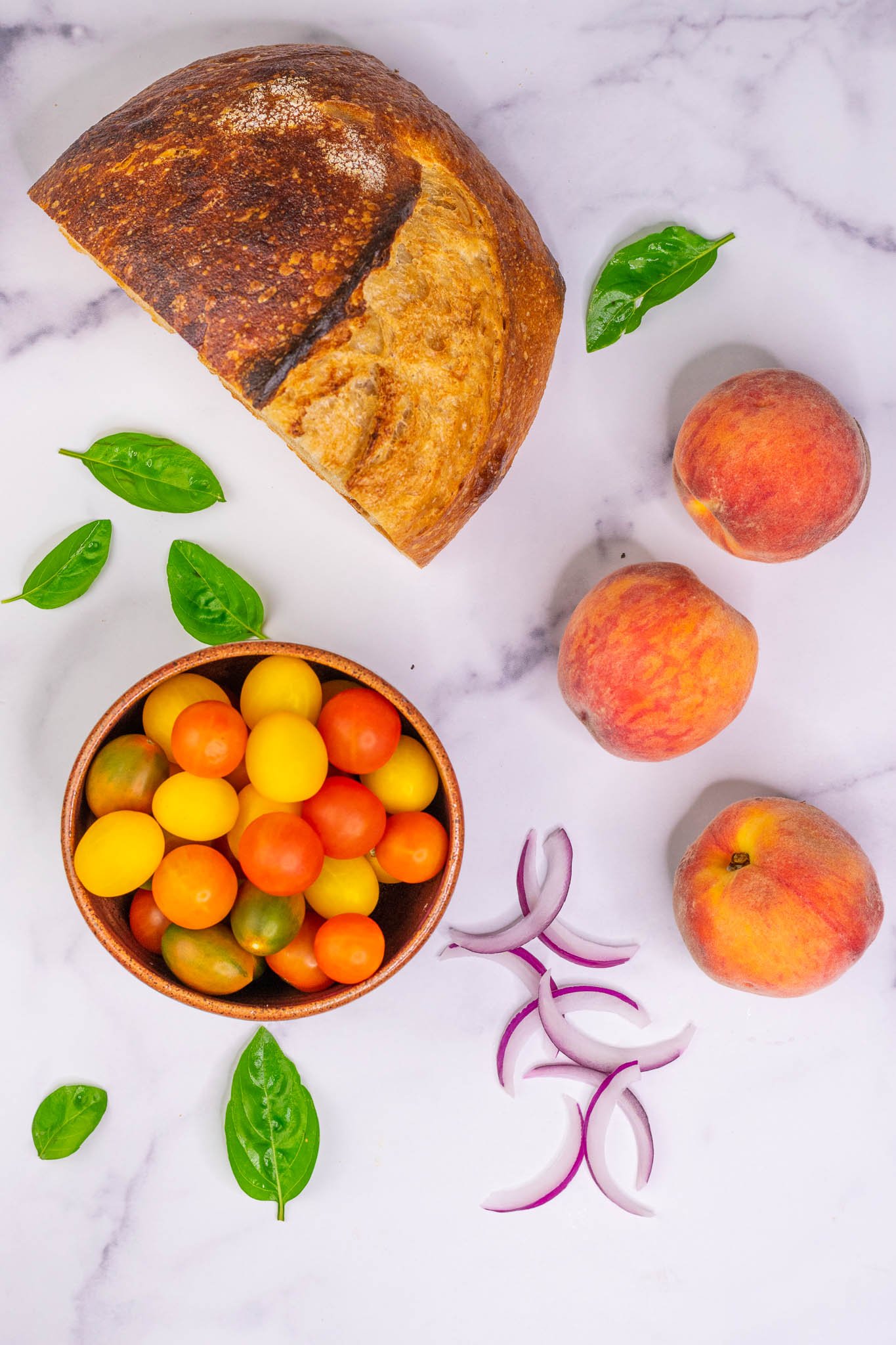 Sourdough bread, peaches, red onion, basil, and a bowl of cherry tomatoes
