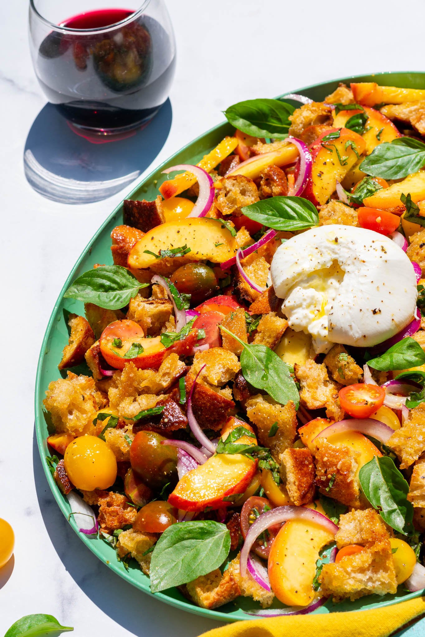 Sourdough panzanella with peaches and burrata on a platter