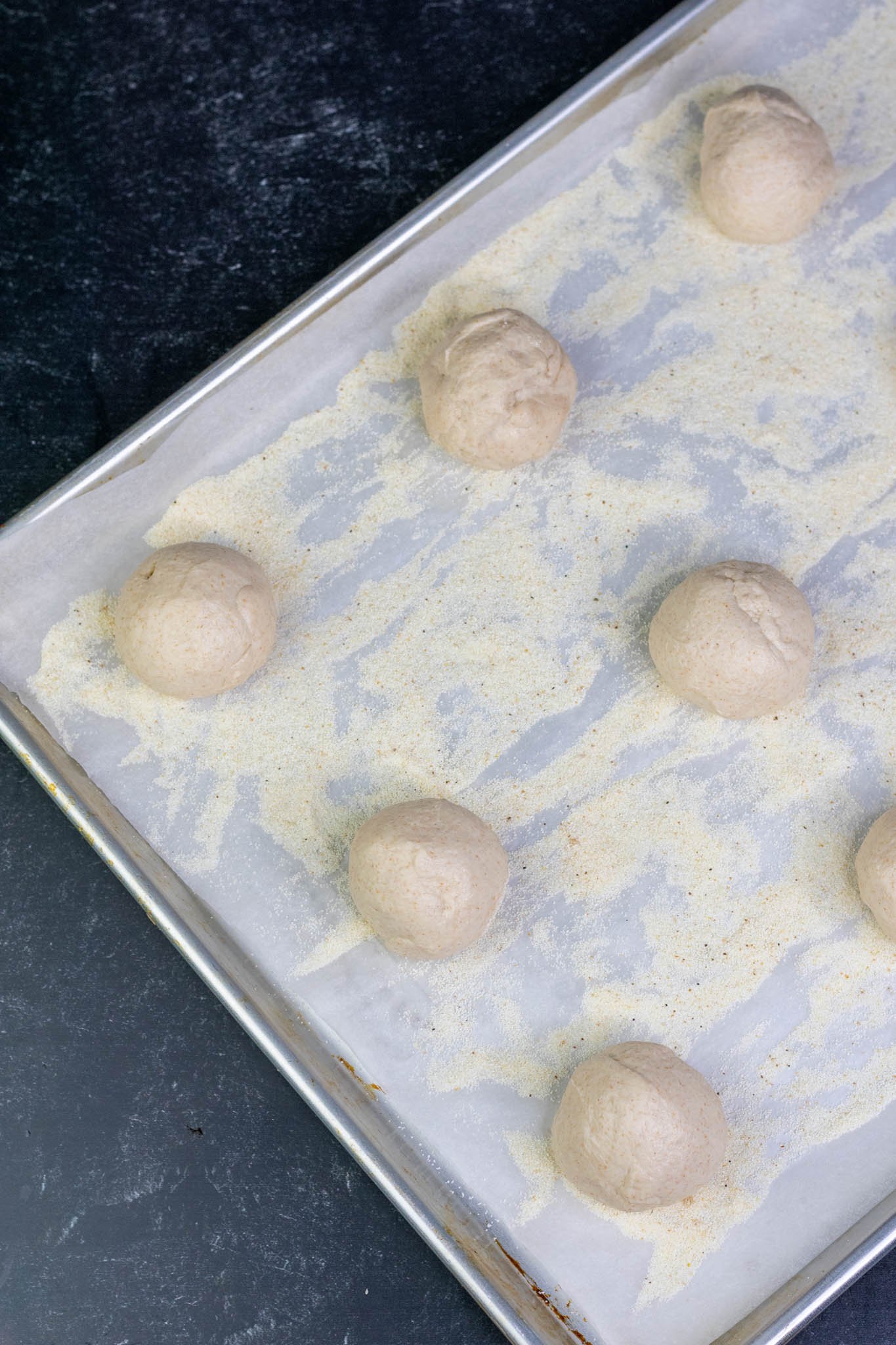Sourdough English Muffins on sheet pan with semolina at the start of final proofing