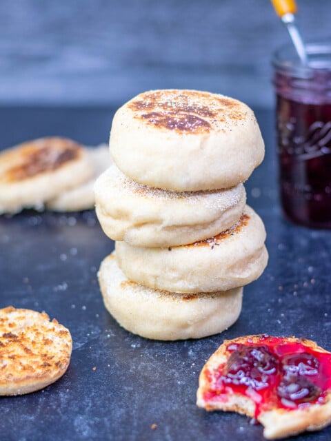 Sourdough english muffins stacked with one toasted with cherry jam