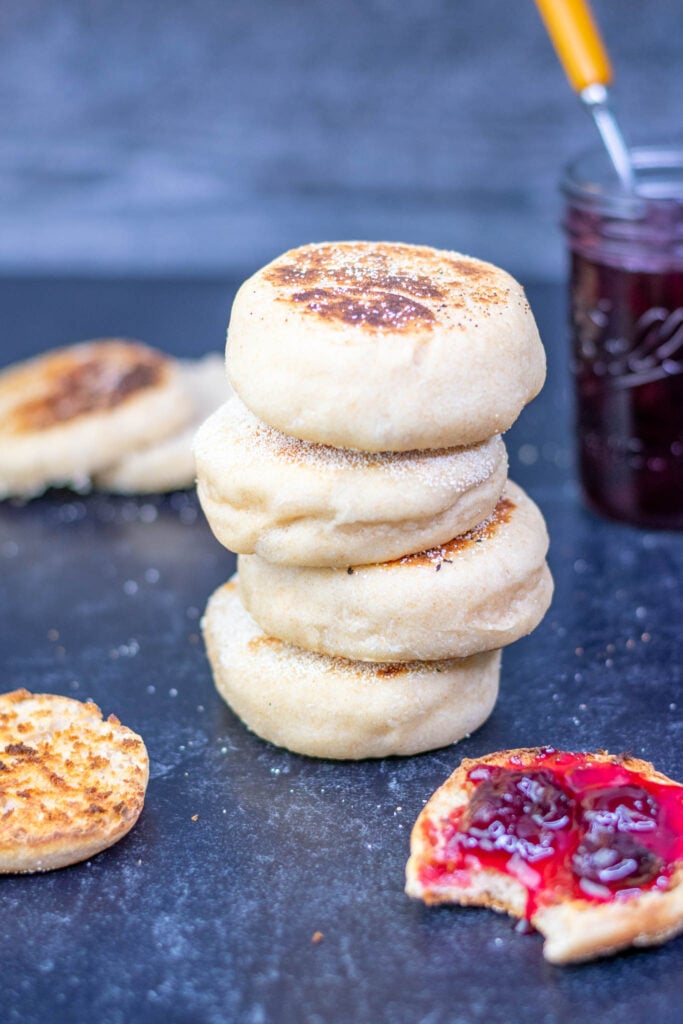 Sourdough english muffins stacked with one toasted with cherry jam