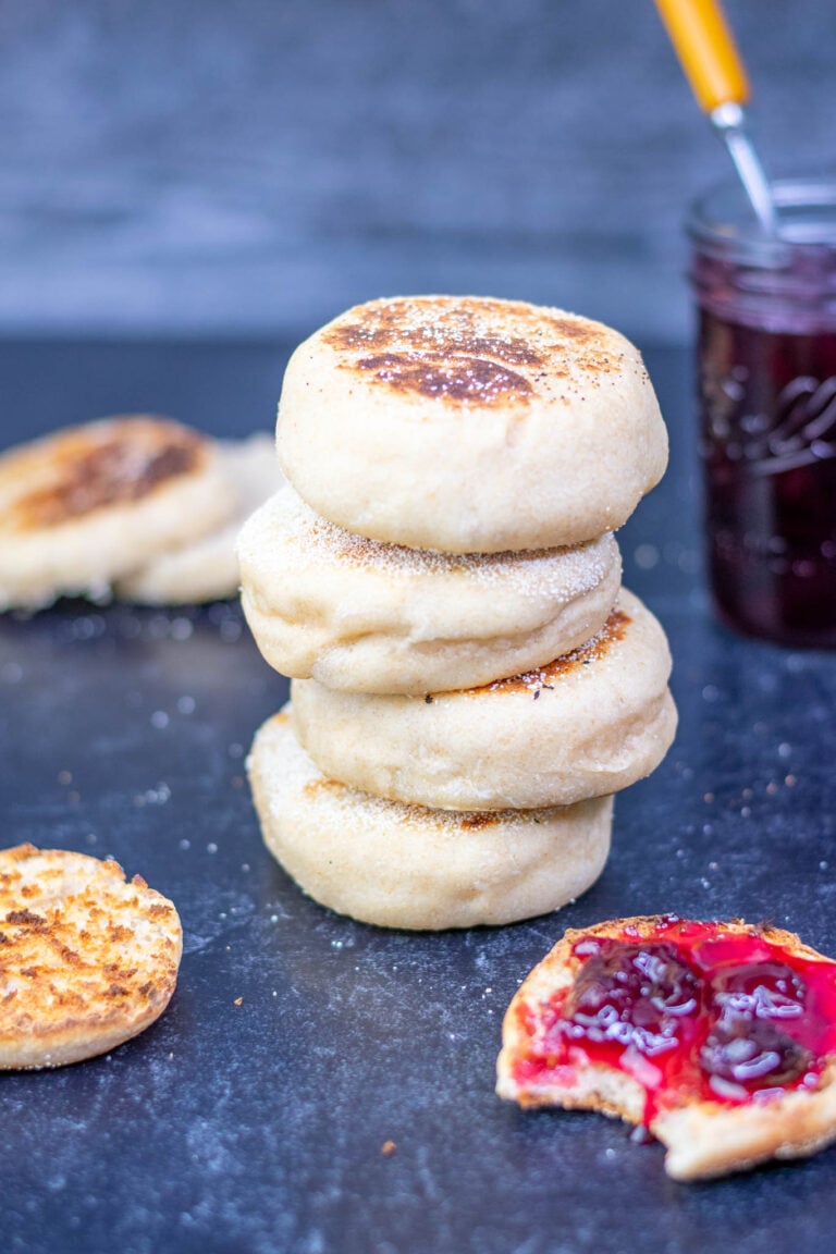Sourdough english muffins stacked with one toasted with cherry jam