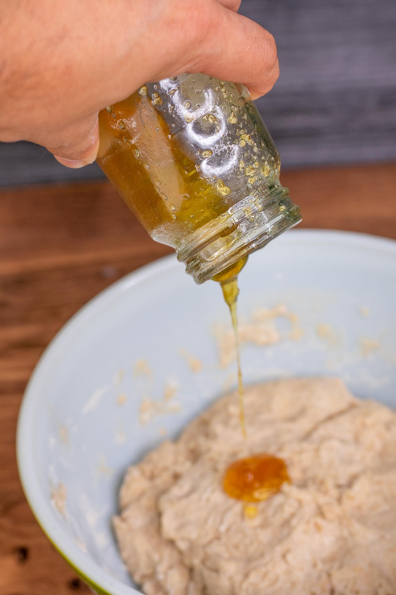 Pouring honey into bowl of dough