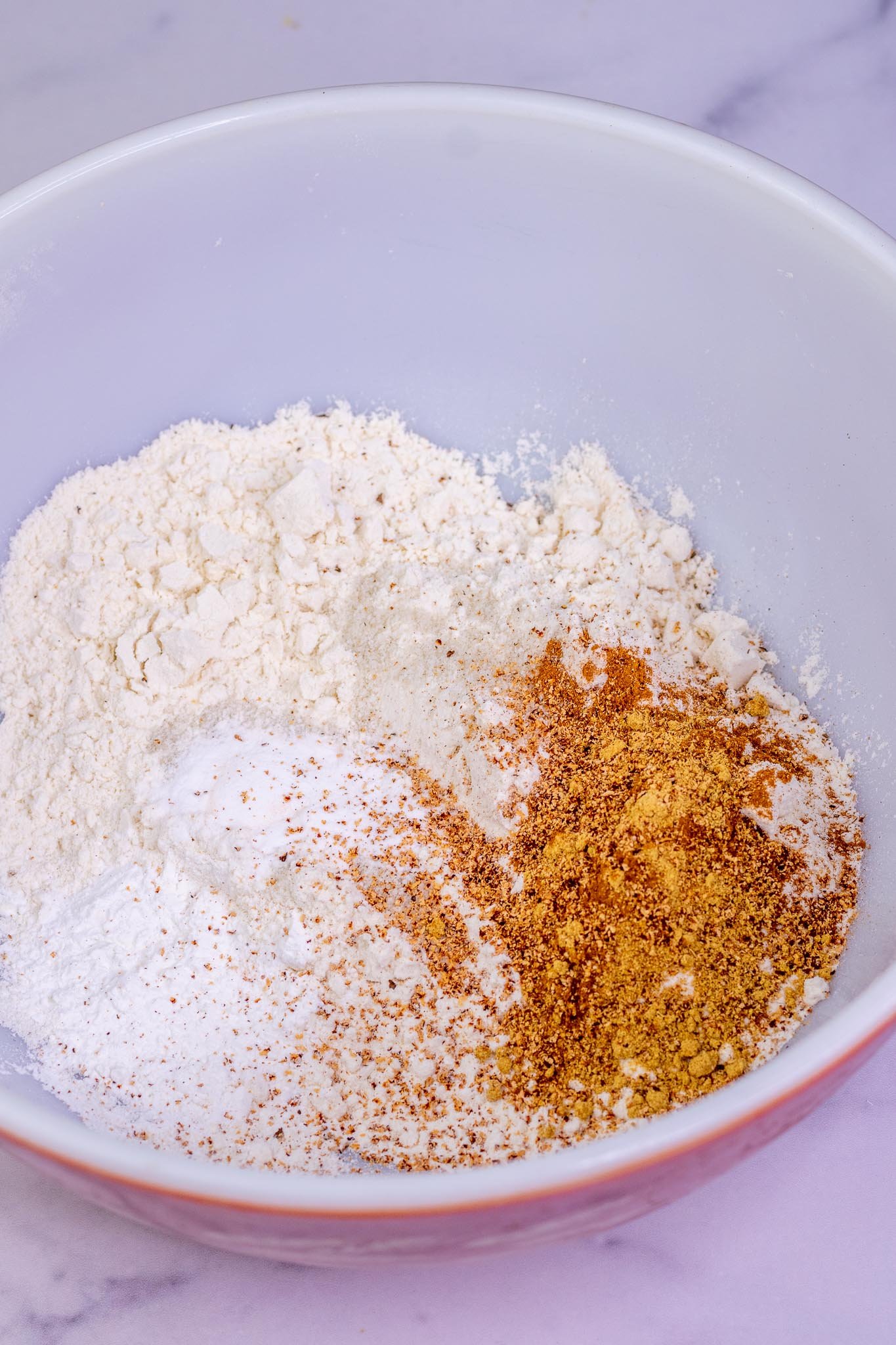 Dry ingredients for Sourdough Pumpkin Waffles in bowl including pumpkin spices