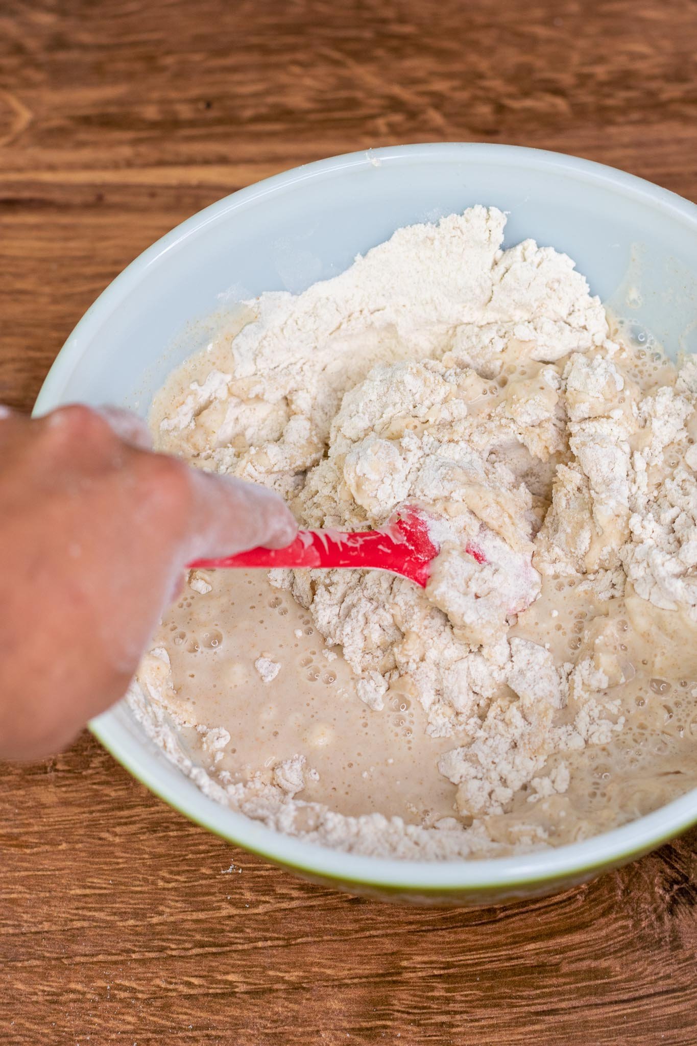 Spatula mixing flours and water for autolyse in bowl