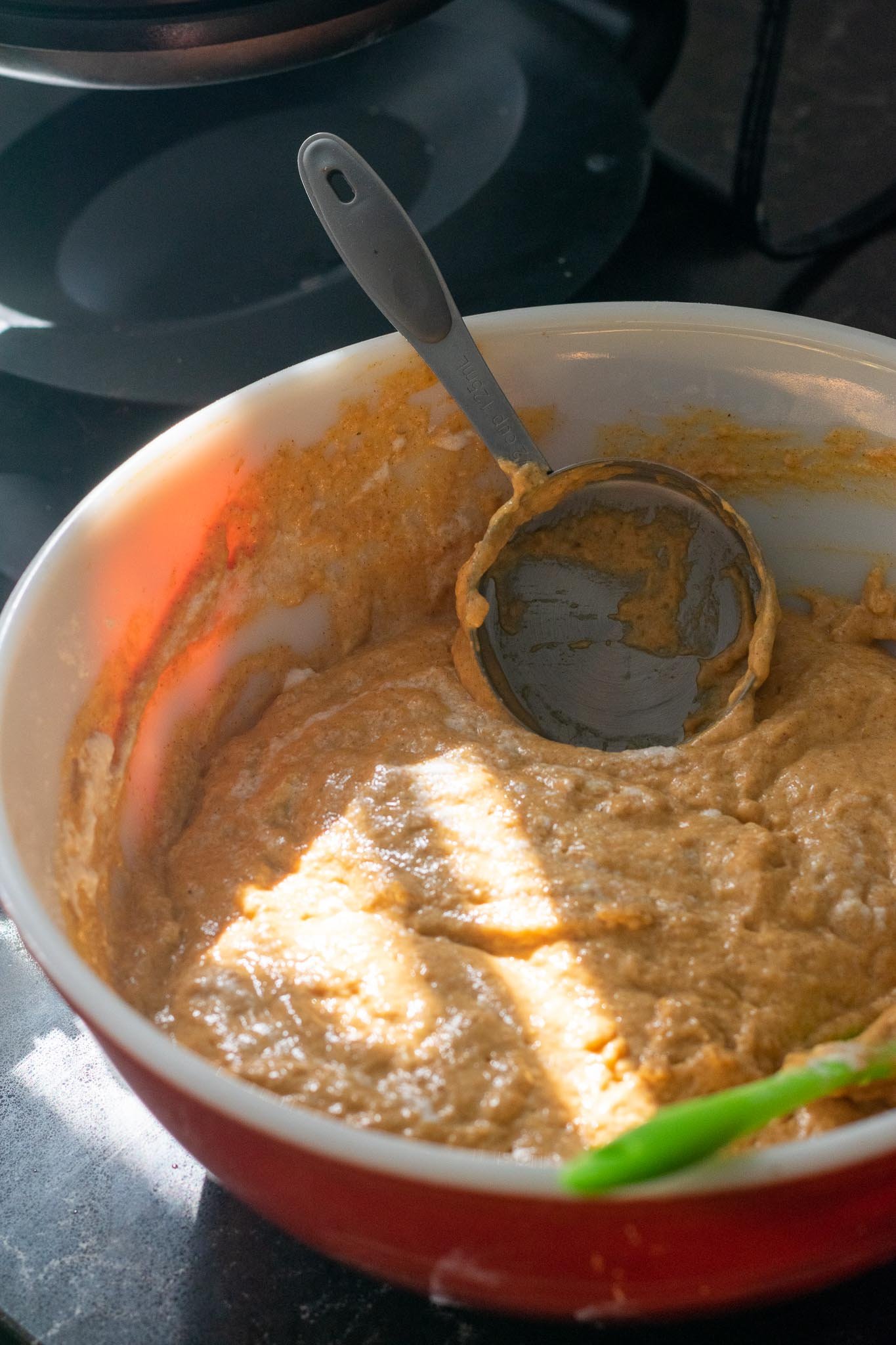 Half cup in Sourdough Pumpkin Waffle batter in bowl
