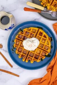 Sourdough pumpkin waffle with whipped cream on plate