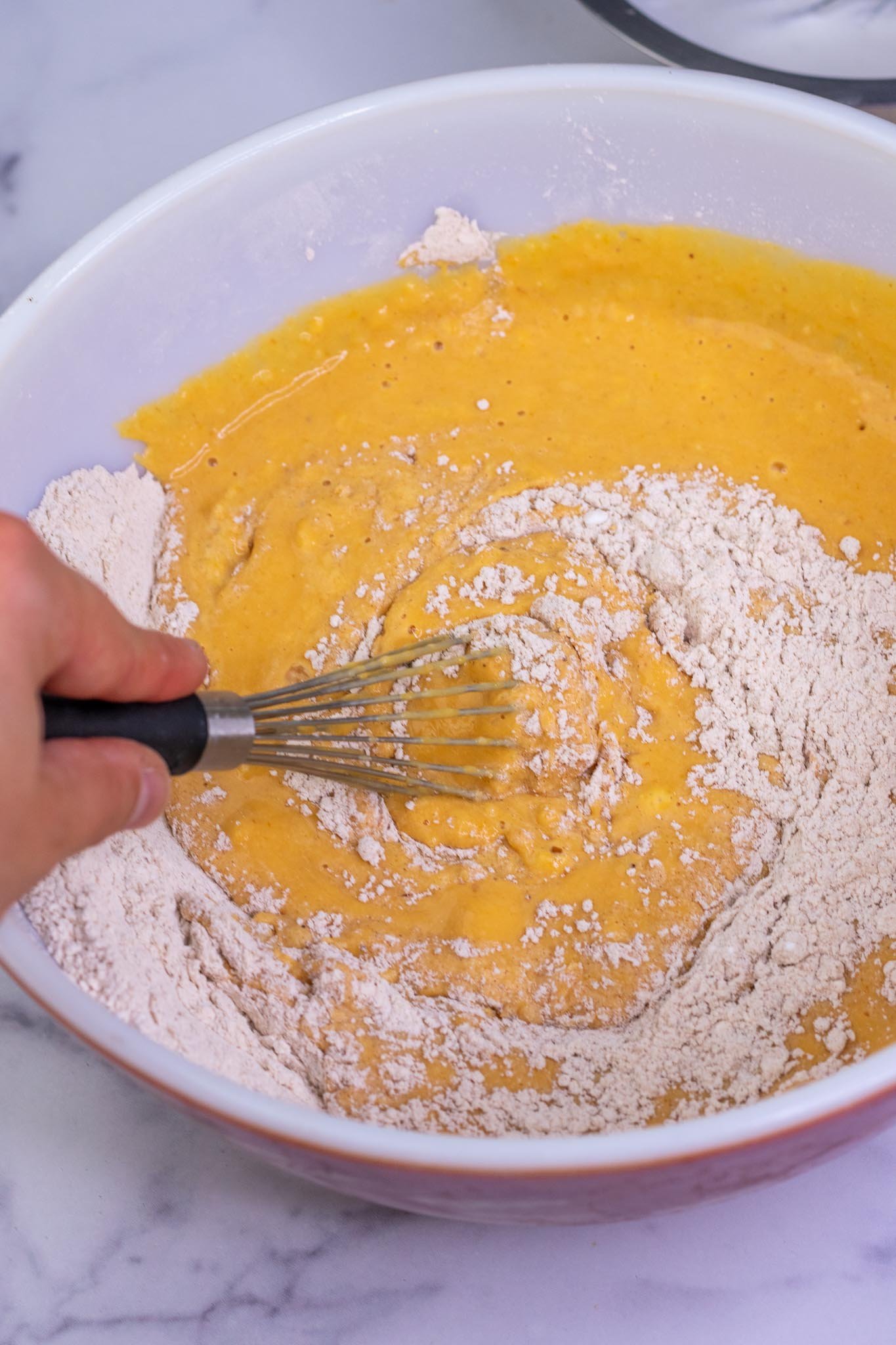Whisking together wet and dry ingredients in bowl
