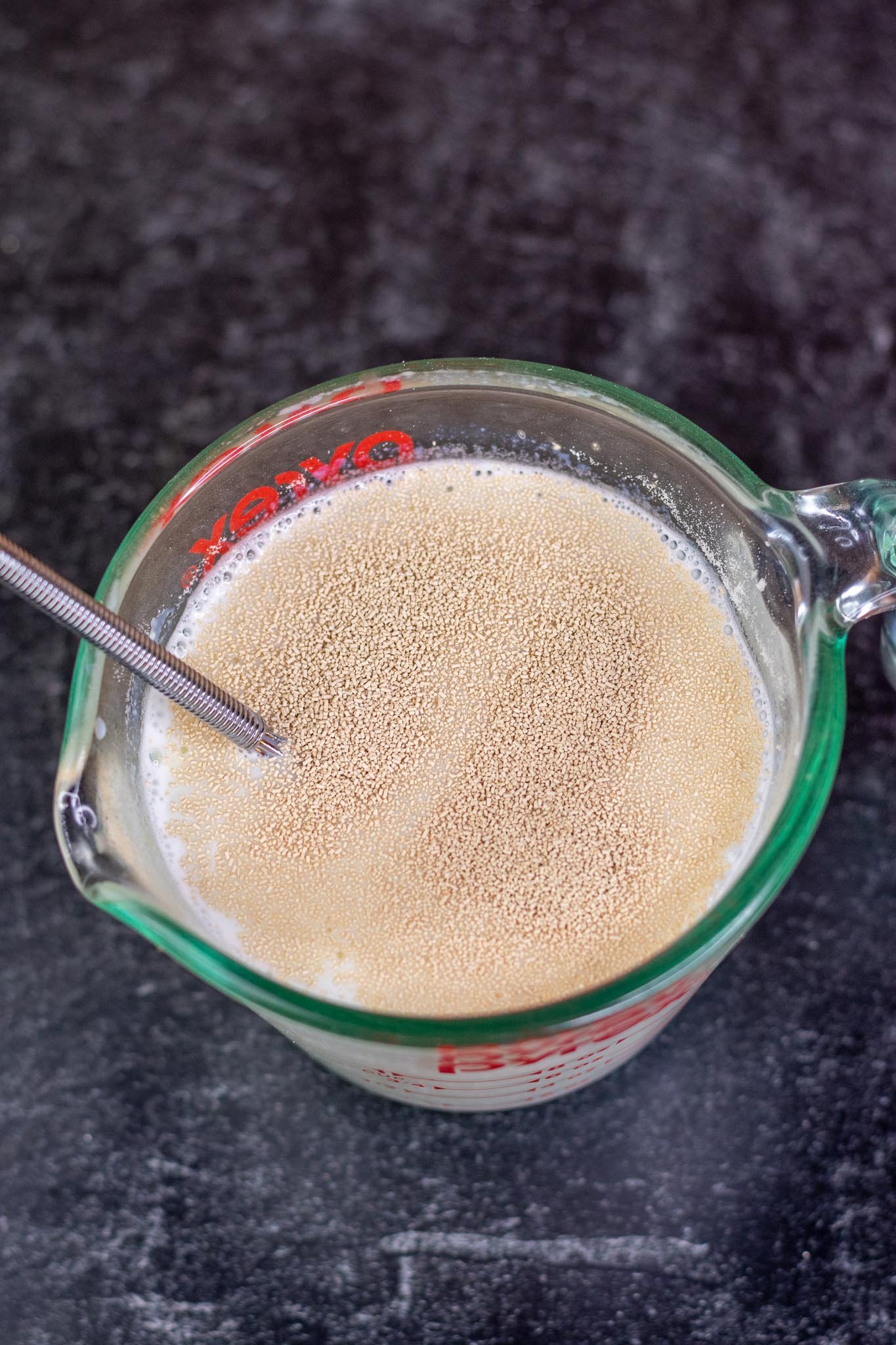 Adding active dry yeast to milk in liquid measuring cup