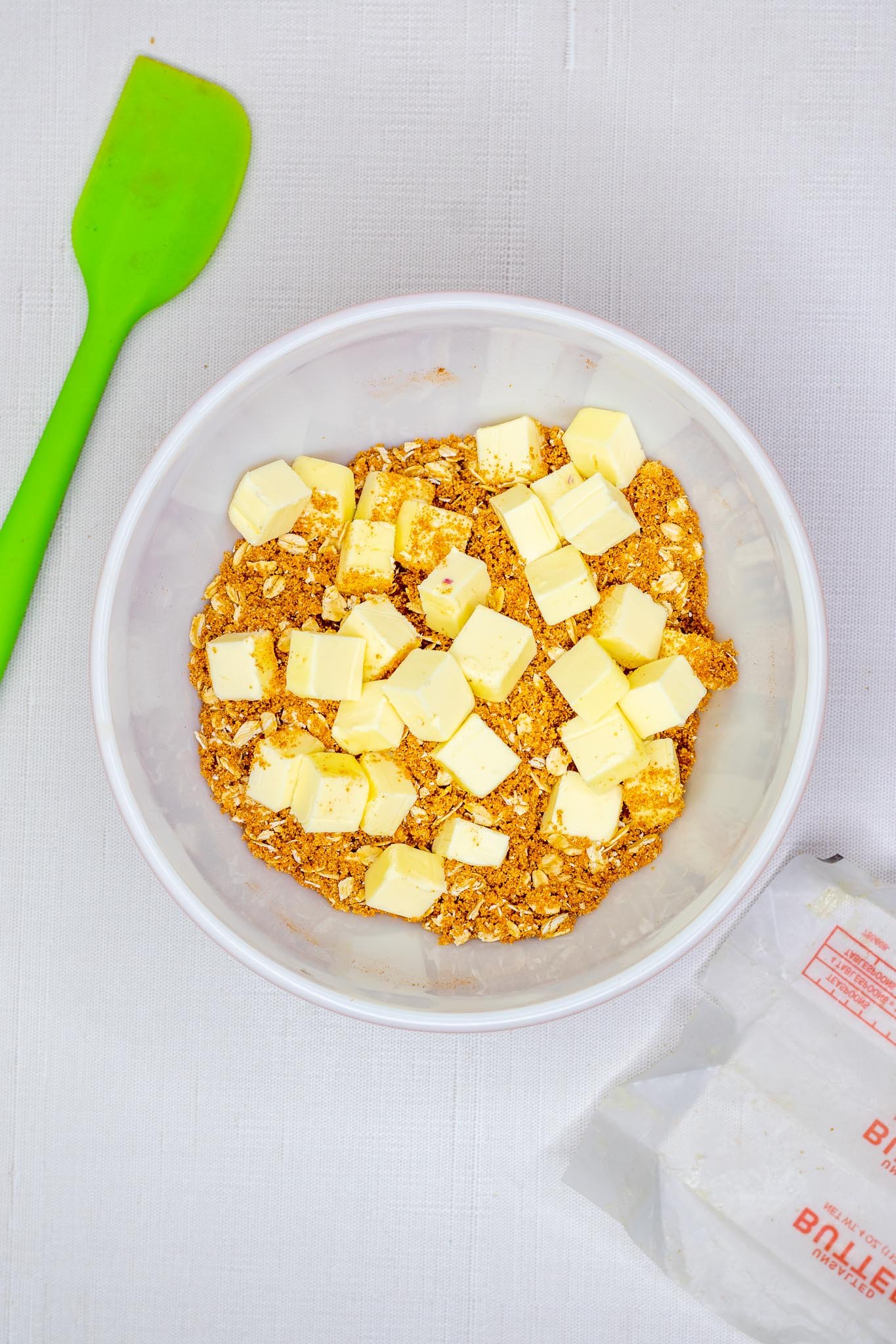 Cubed butter in bowl with streusel ingredients