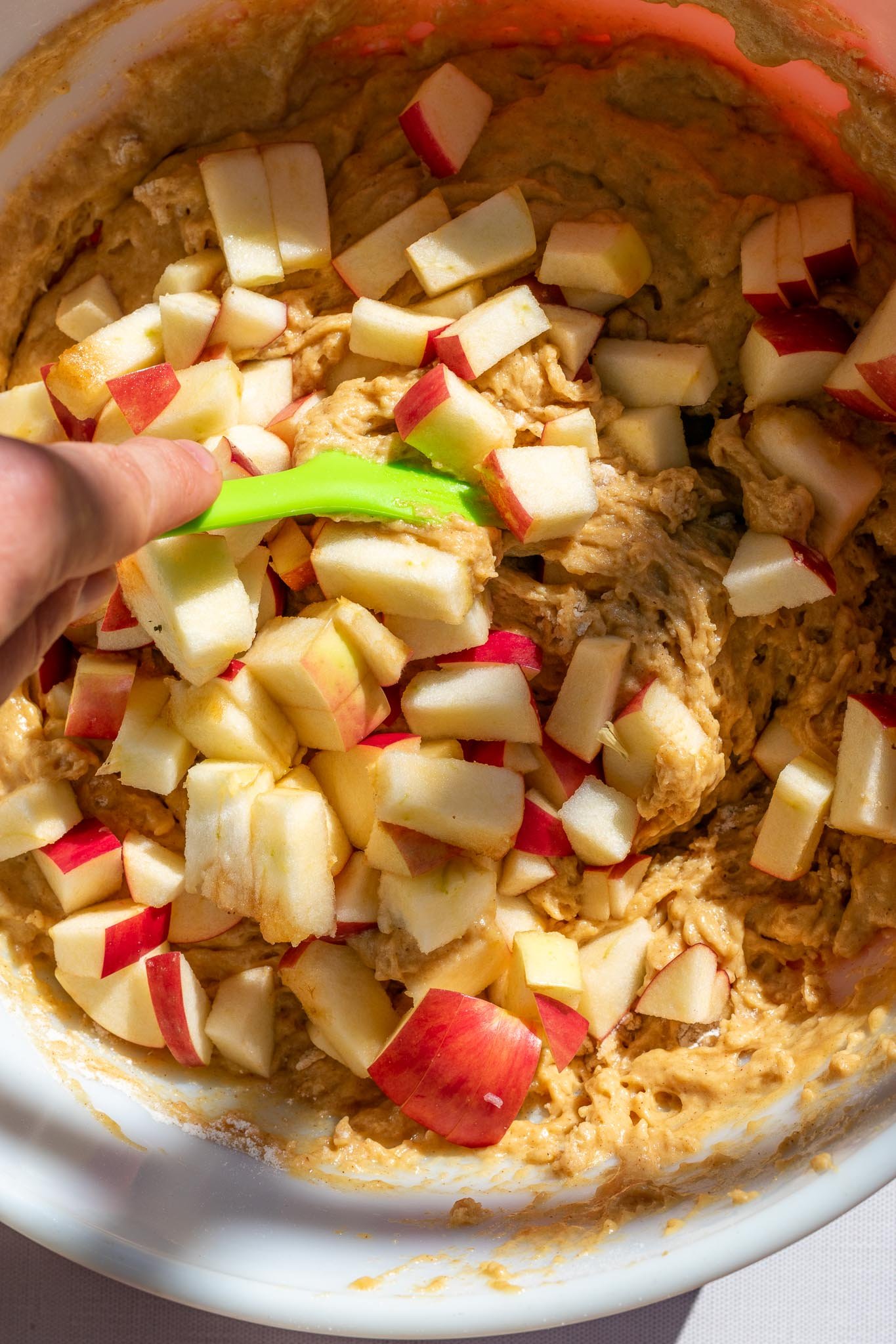 Folding apples into sourdough apple butter muffin batter