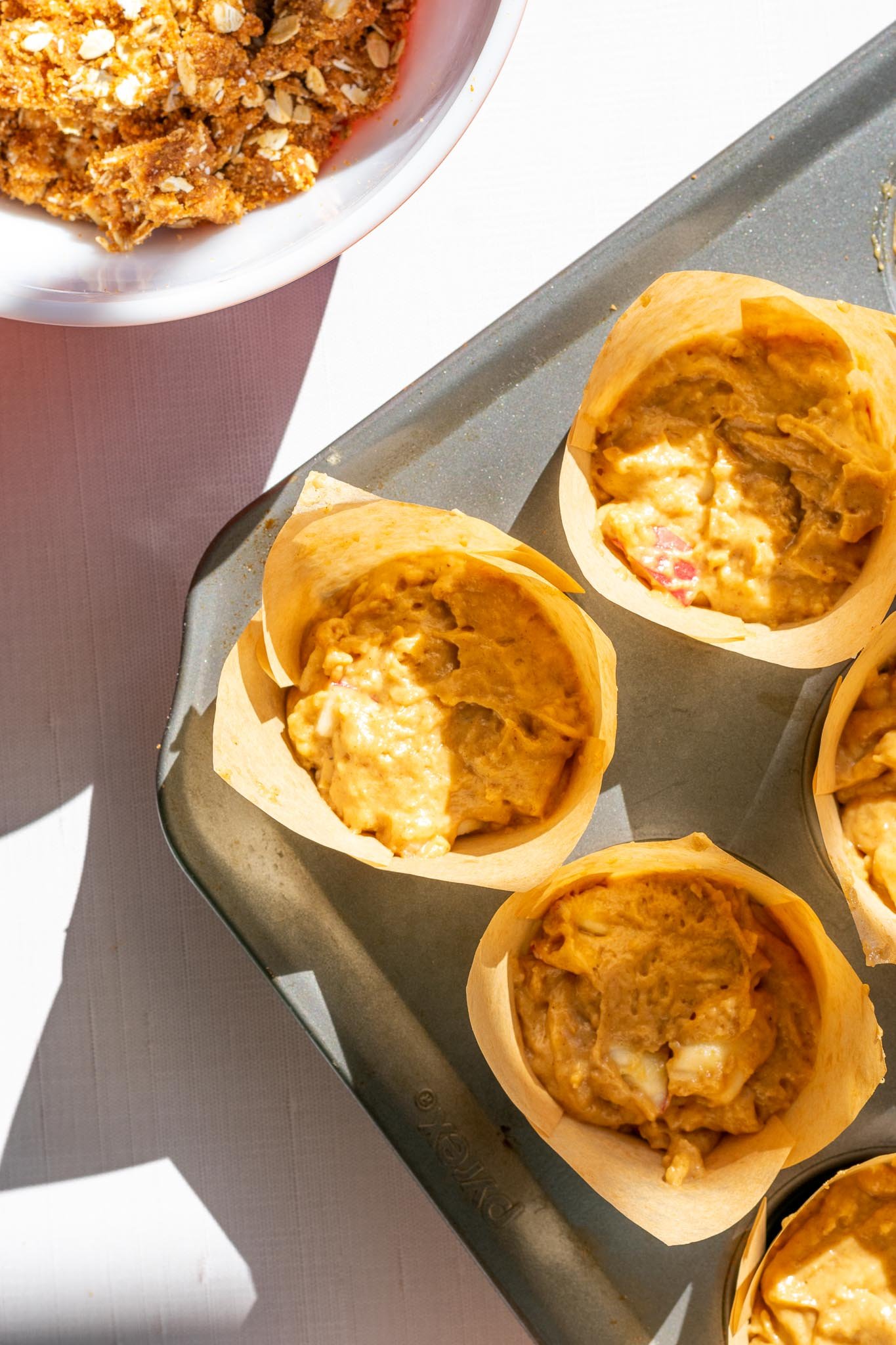 Muffin pan filled with sourdough apple butter muffin batter