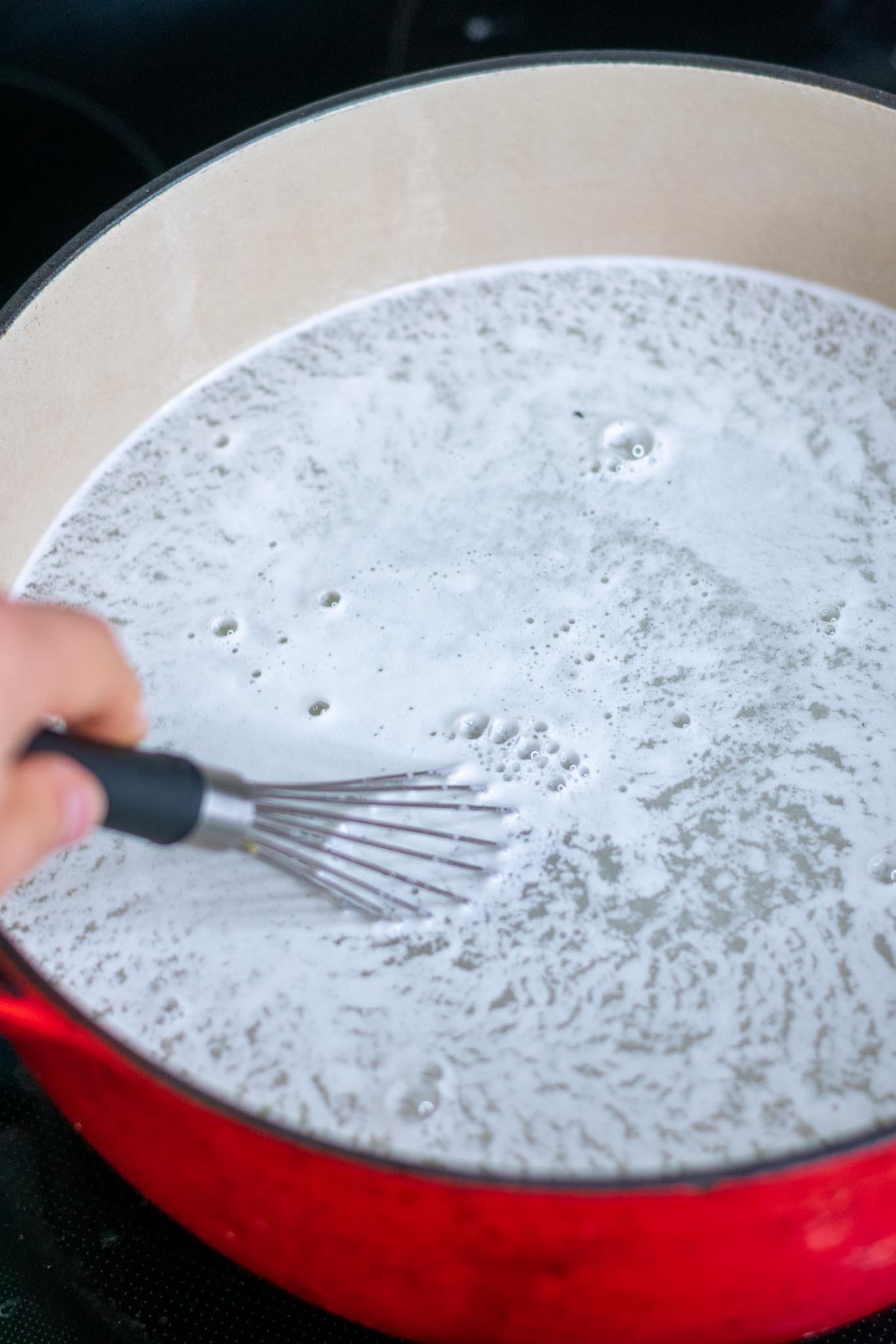 Whisking baked baking soda in a dutch oven with water