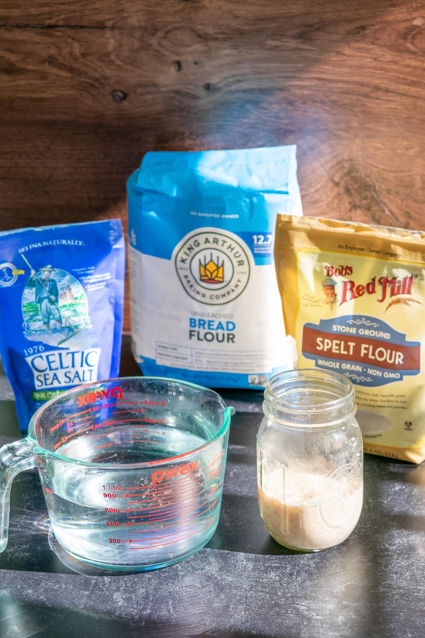 Ingredients needed for Spelt Sourdough Bread including sourdough starter, water, salt, bread flour, and spelt flour