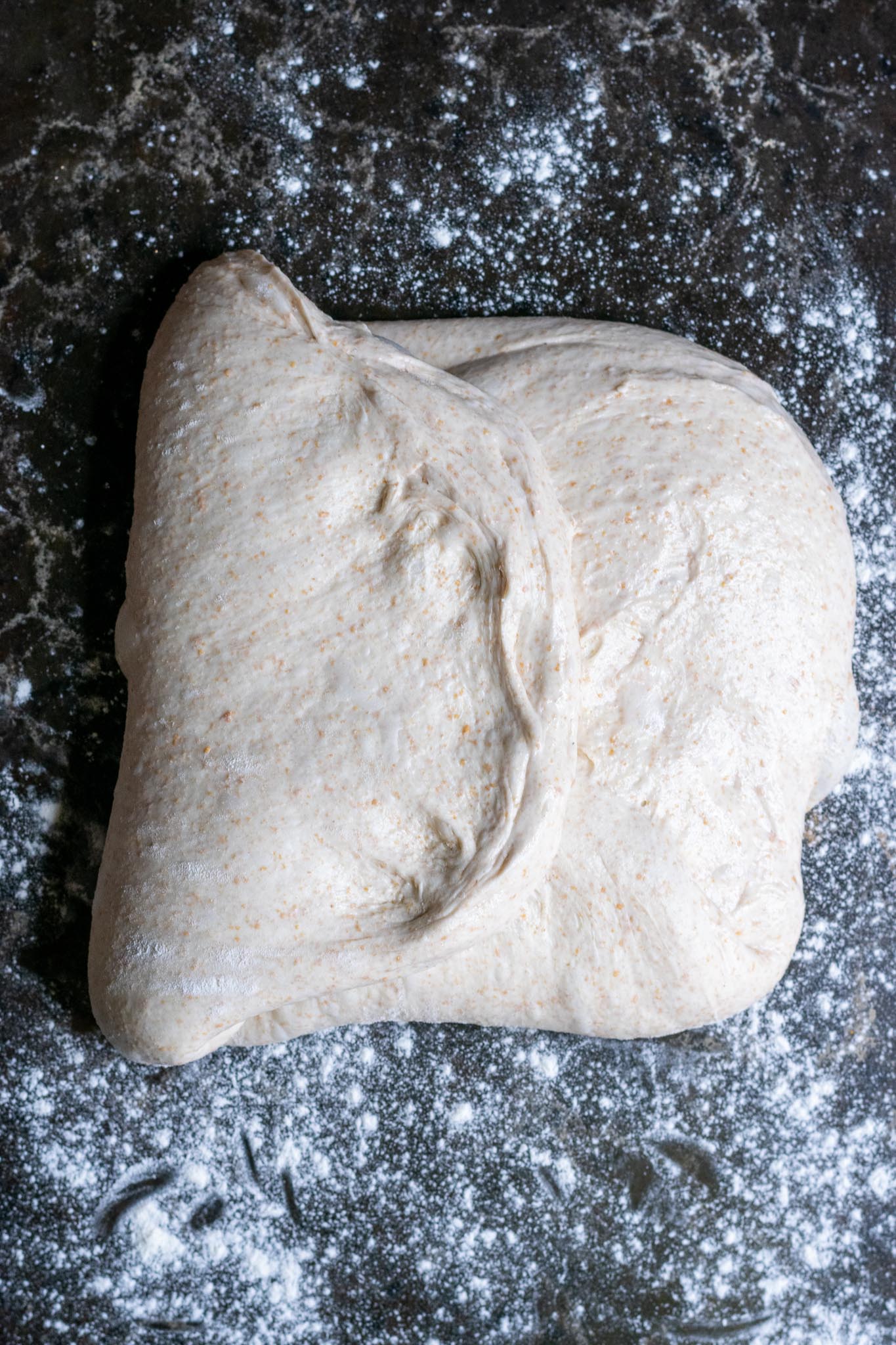 Folding dough into an envelop with left side folded over