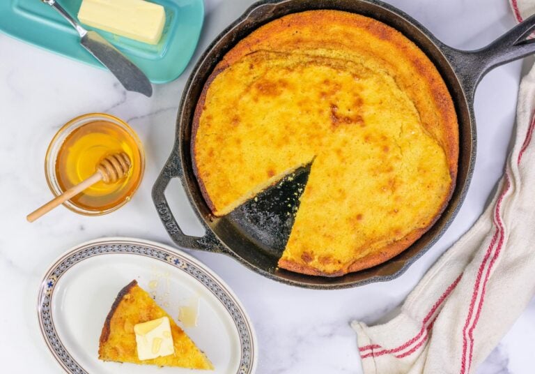 Sourdough Honey Cornbread in cast iron skillet with butter and honey