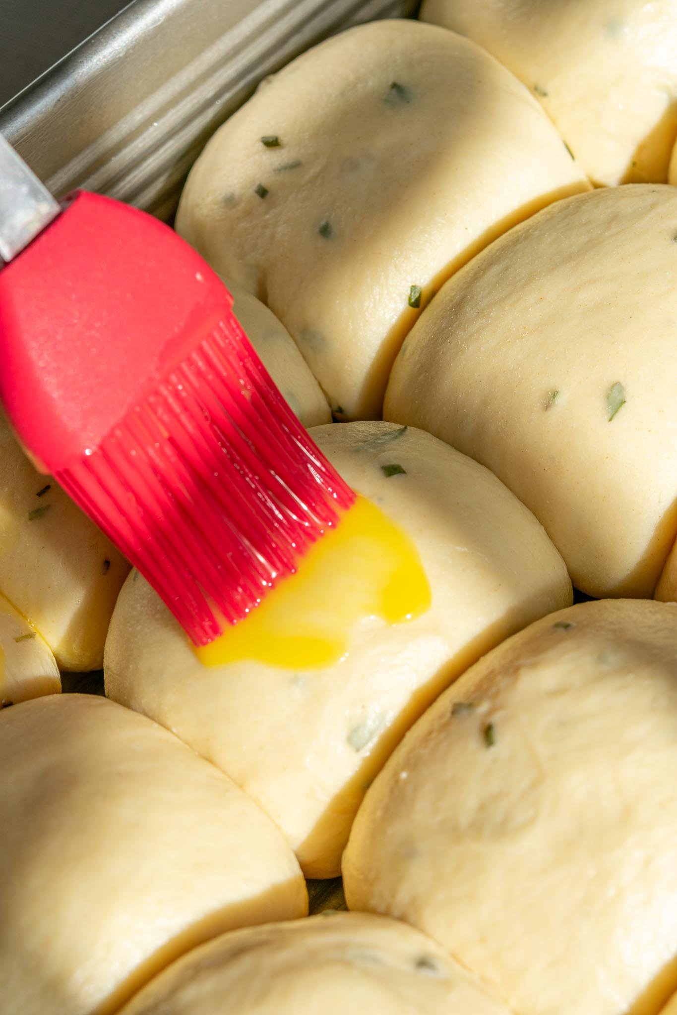 Brushing egg wash on dinner rolls