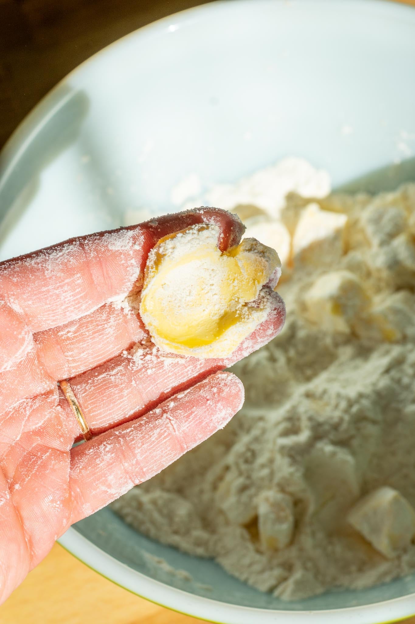 Hand holding a piece of smashed butter
