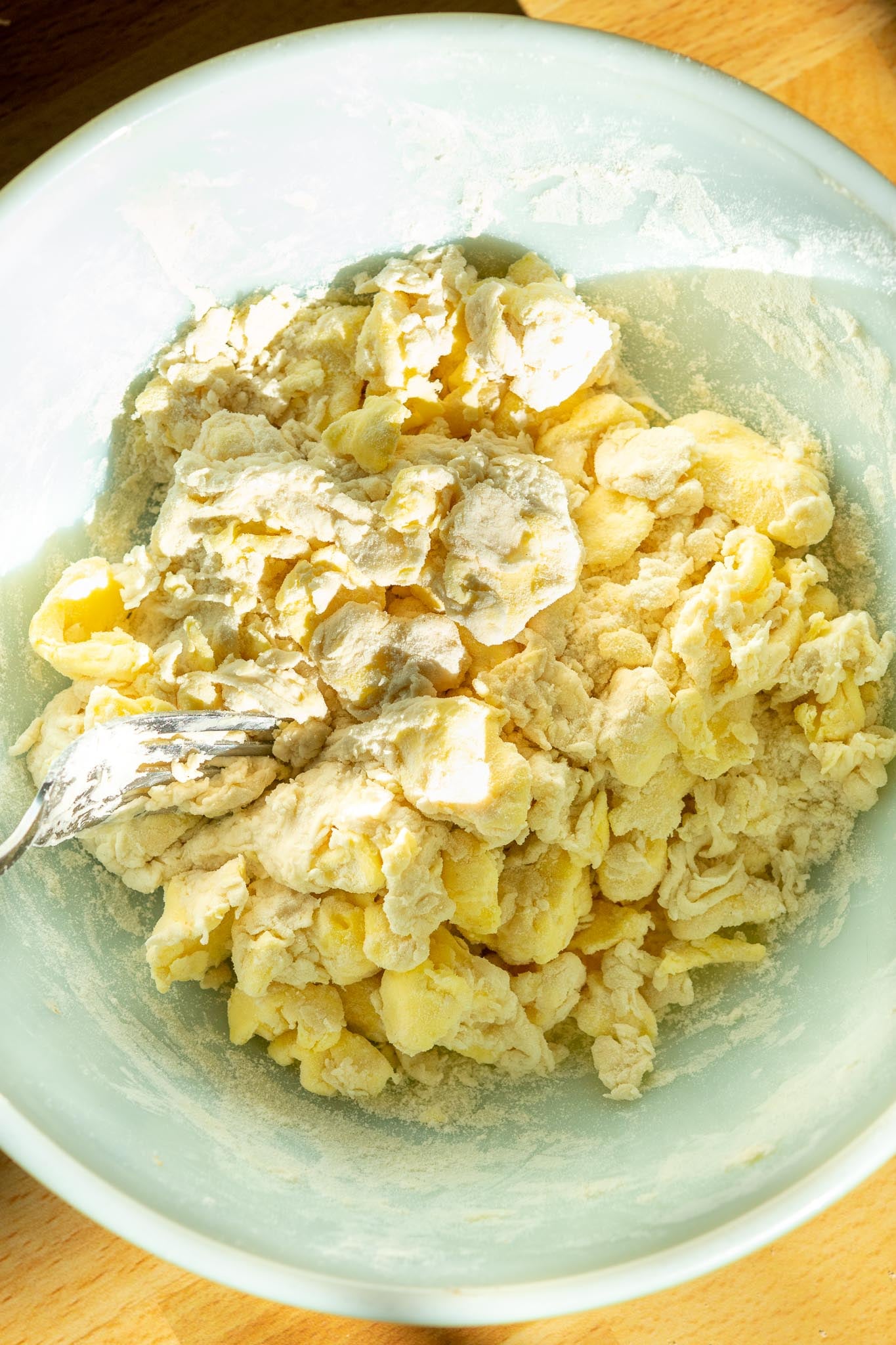 Mixing Sourdough Pie dough with fork in bowl