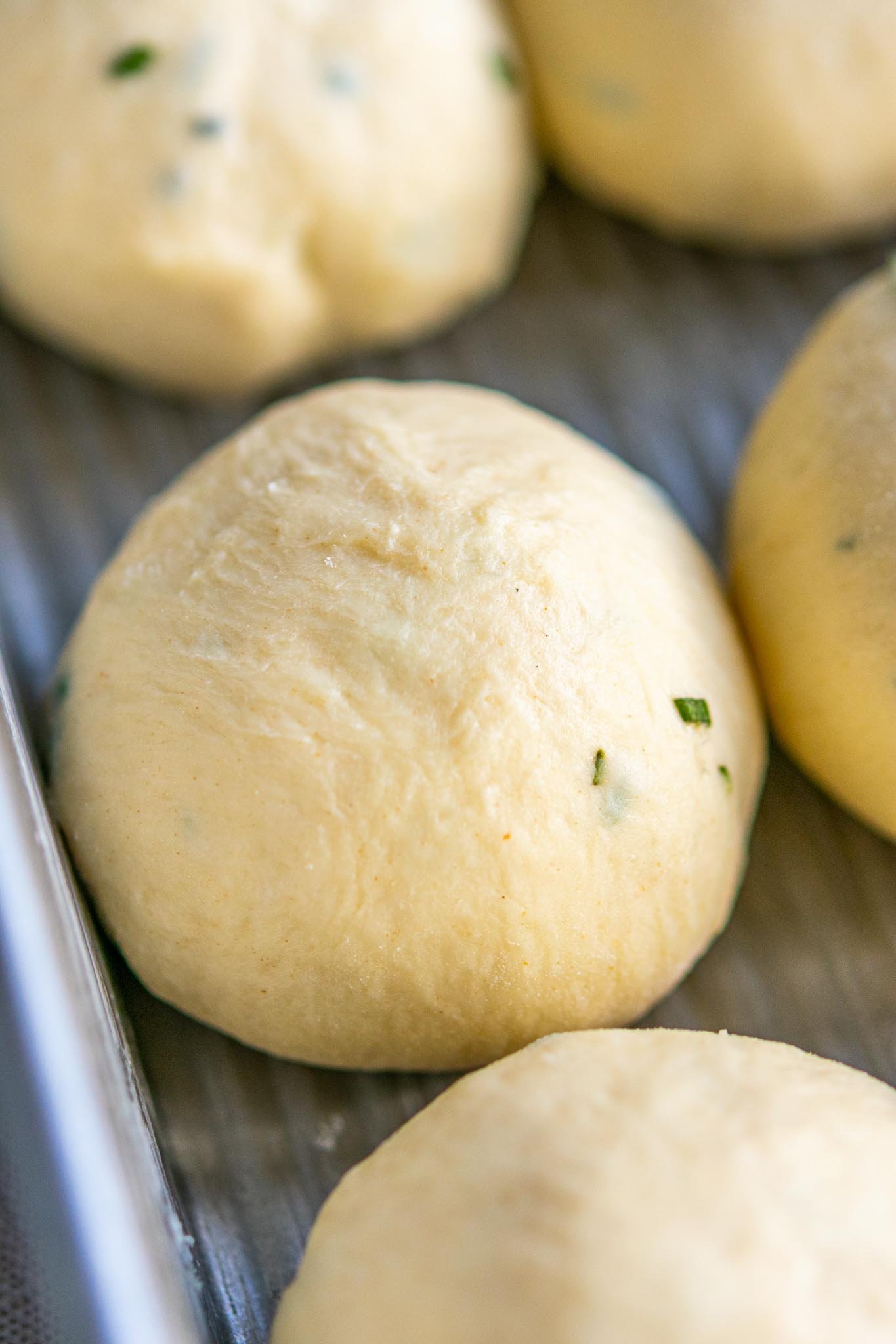 Close up of a sourdough dinner roll in pan at the start of the final proof
