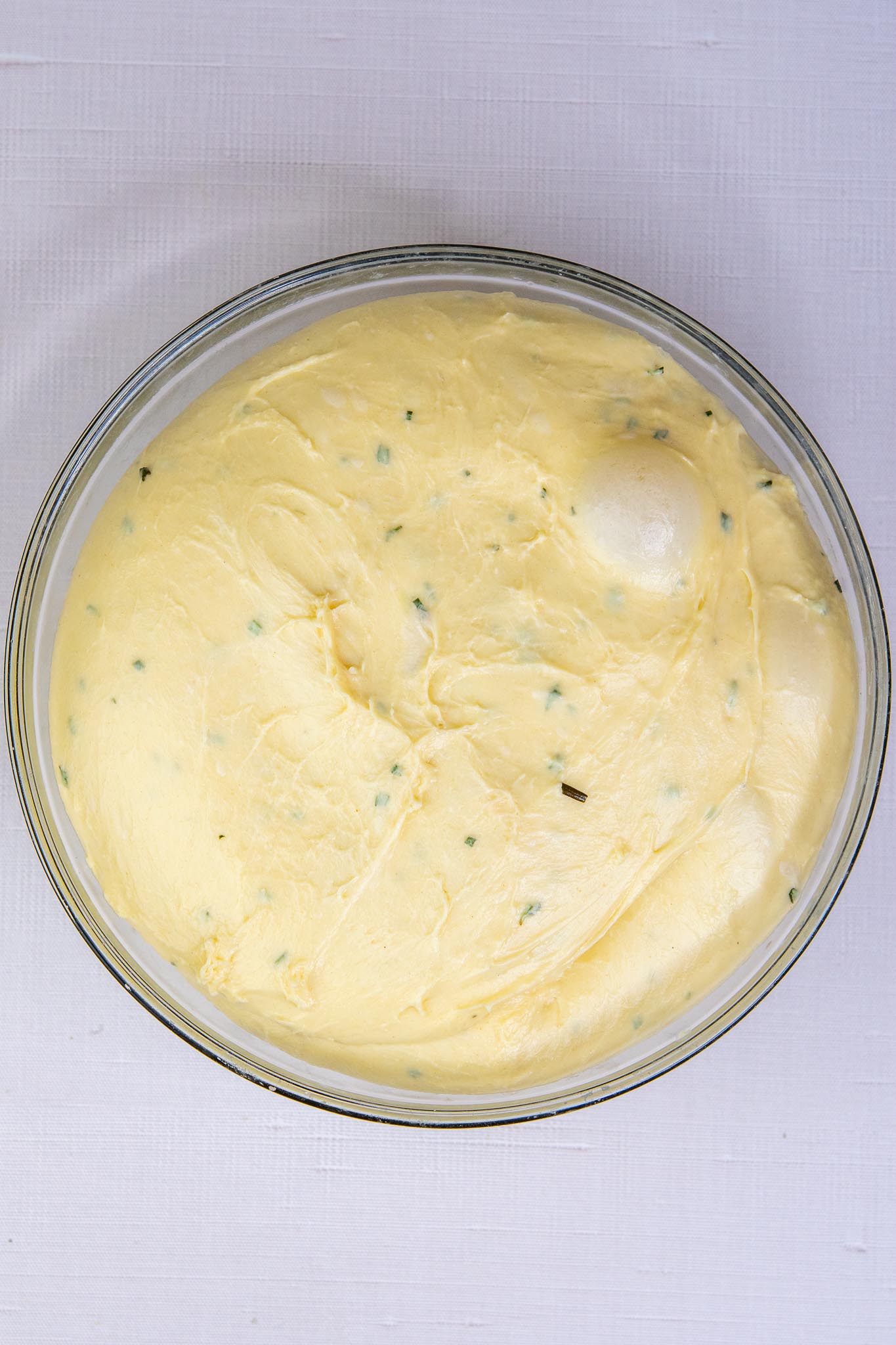 Sourdough dinner roll dough doubled in size in a bowl at the end of bulk fermentation