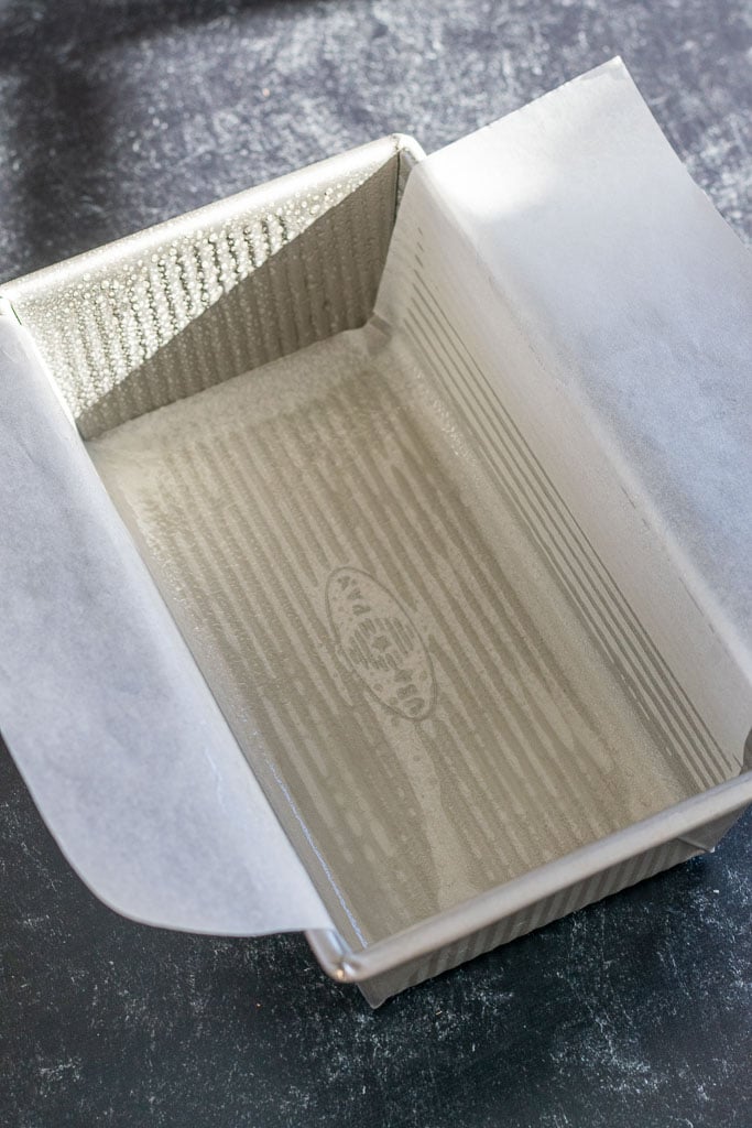 Prepared bread loaf pan sprayed with oil with parchment paper