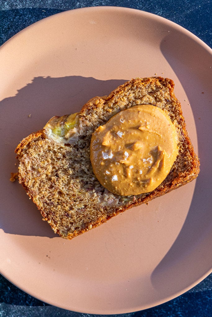Slice of sourdough banana bread with a dollop of peanut butter and flaky salt